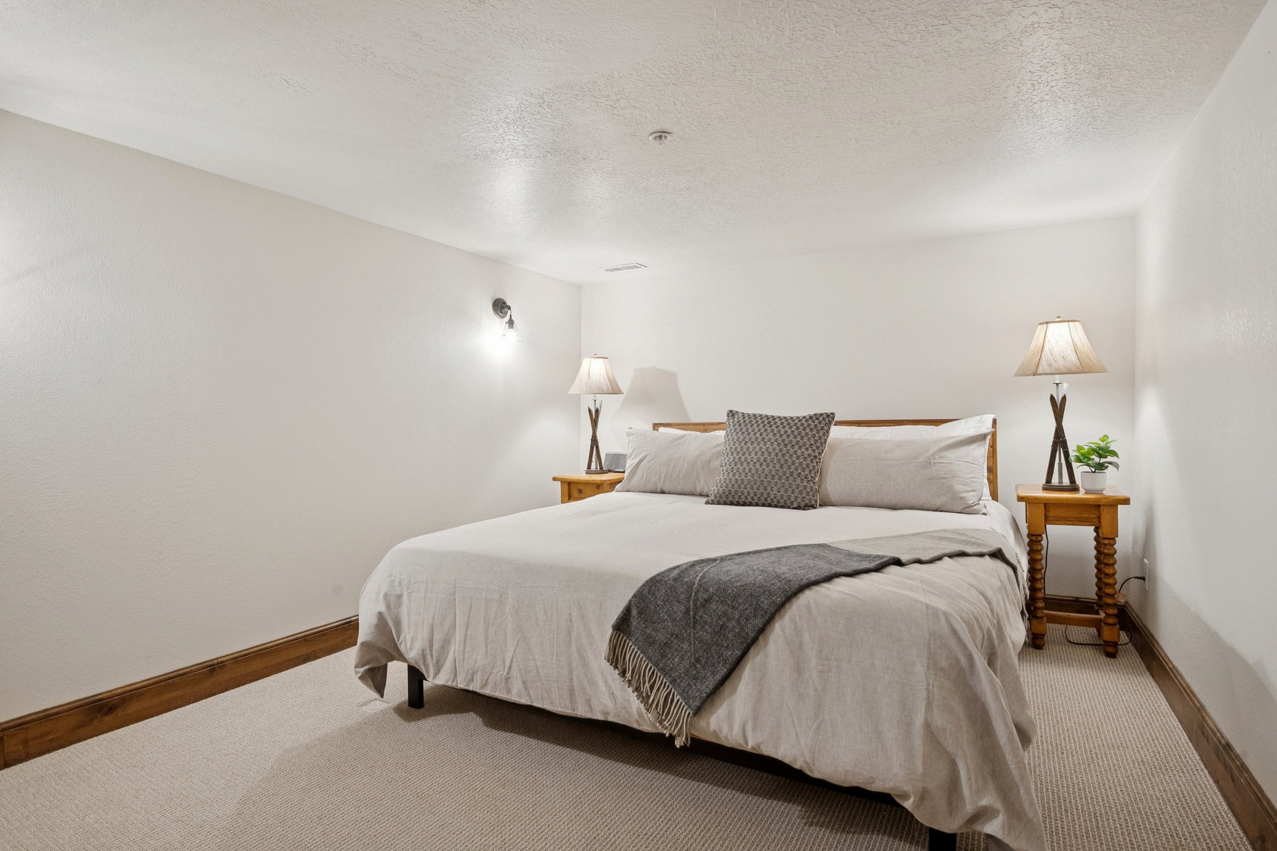 Neutral white walls complement light-toned carpeting and wood-finish baseboards
