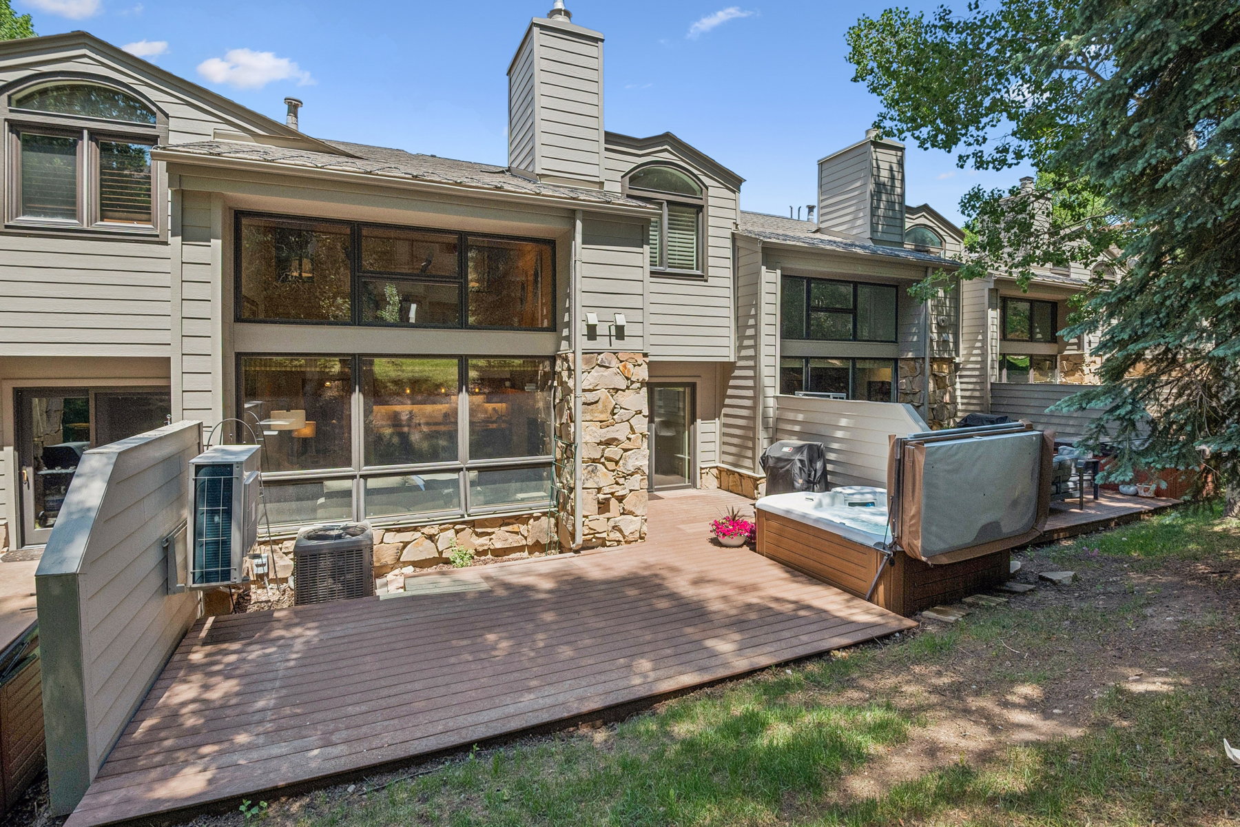 Expansive wood-finish deck featuring a built-in hot tub