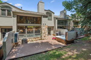 Expansive wood-finish deck featuring a built-in hot tub