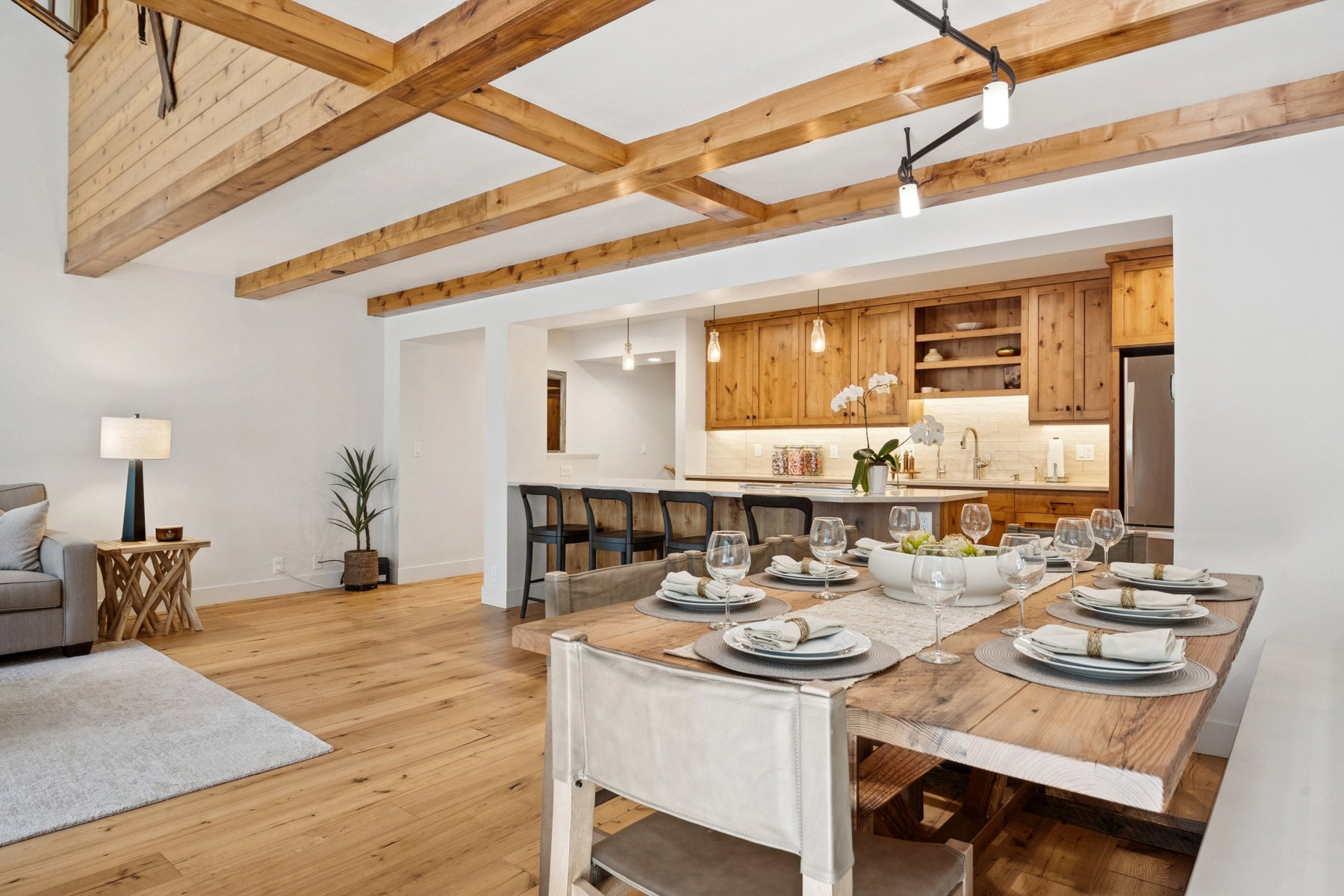 Open-concept dining area featuring a long wood dining table with bench seating