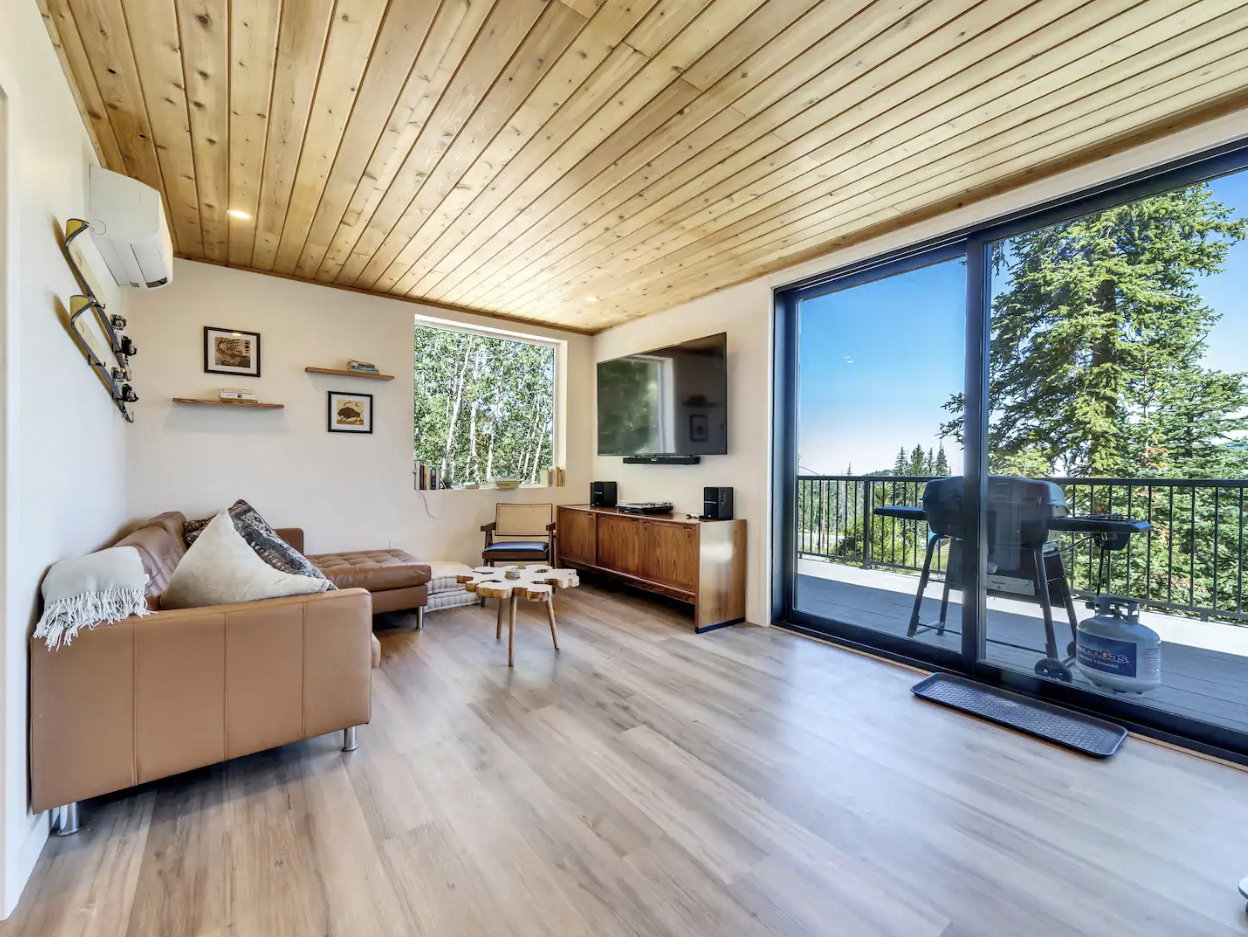 Spacious living area featuring wood-finish flooring and a wood-paneled ceiling