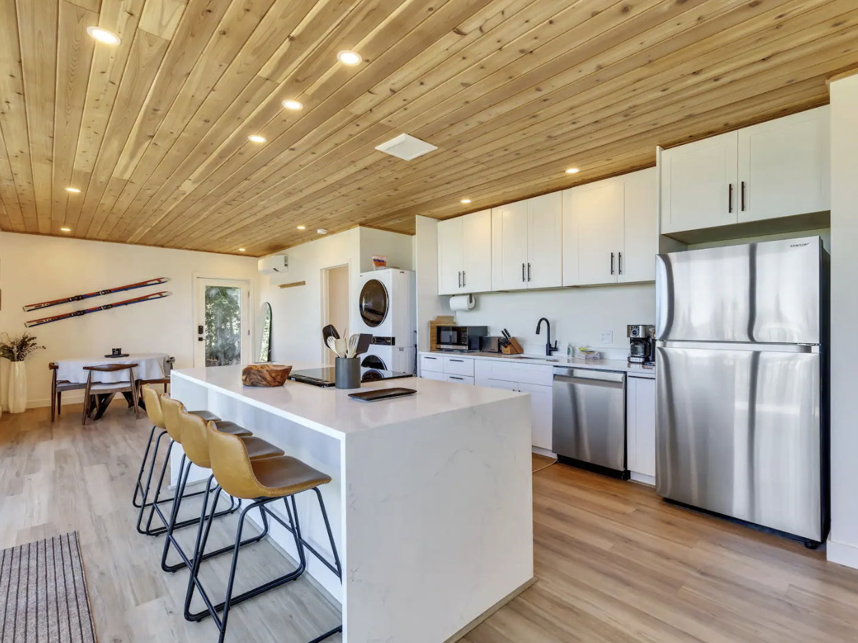 Modern kitchen and dining area featuring a wood-plank ceiling, recessed lighting, and light wood-finish flooring