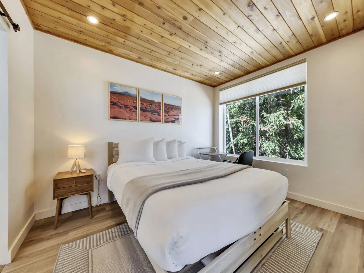 Bedroom featuring a natural wood plank ceiling with recessed lighting, a large window, light wood-finish flooring, and white baseboards