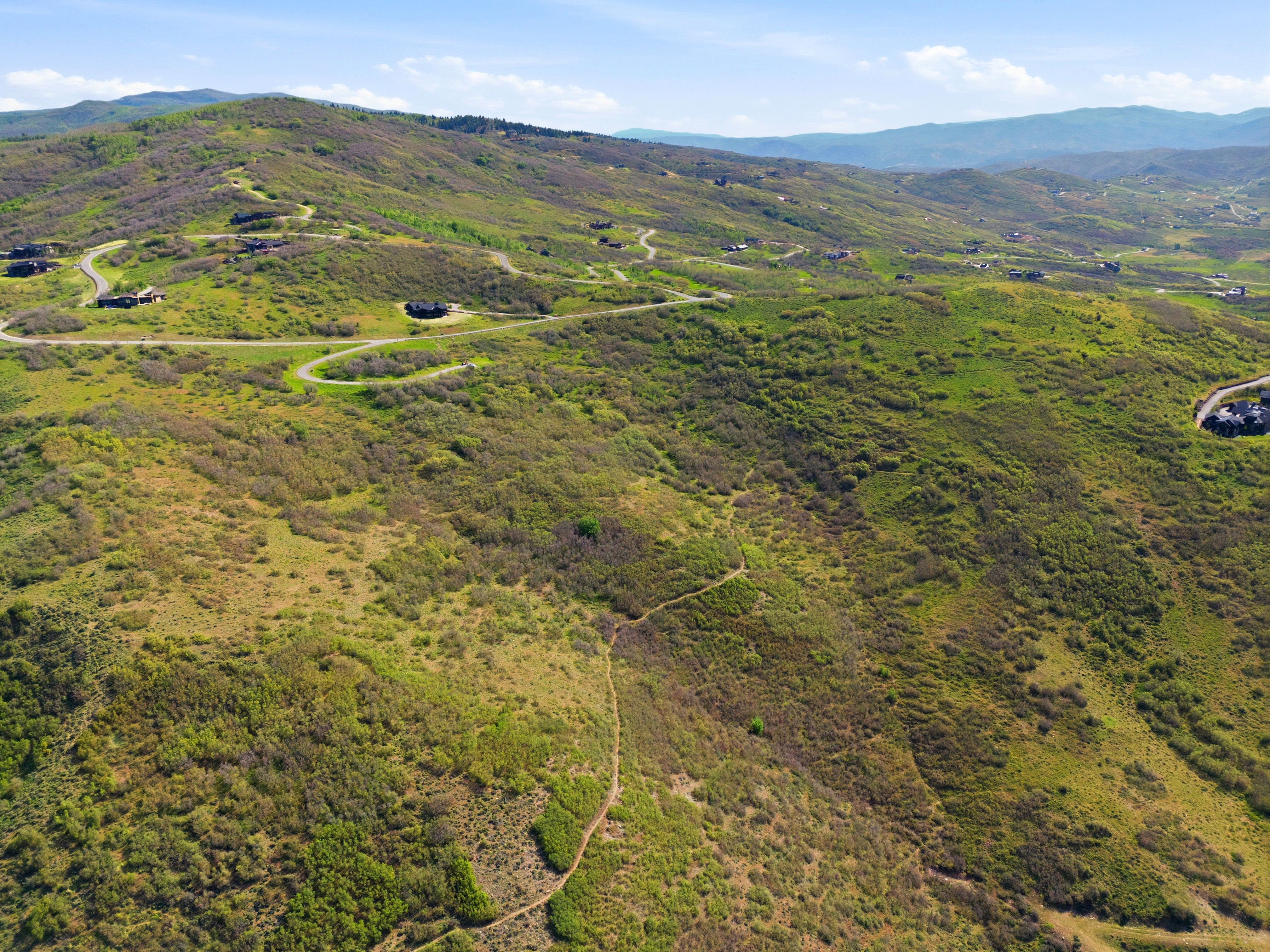 Expansive mountainous terrain featuring scattered residential structures