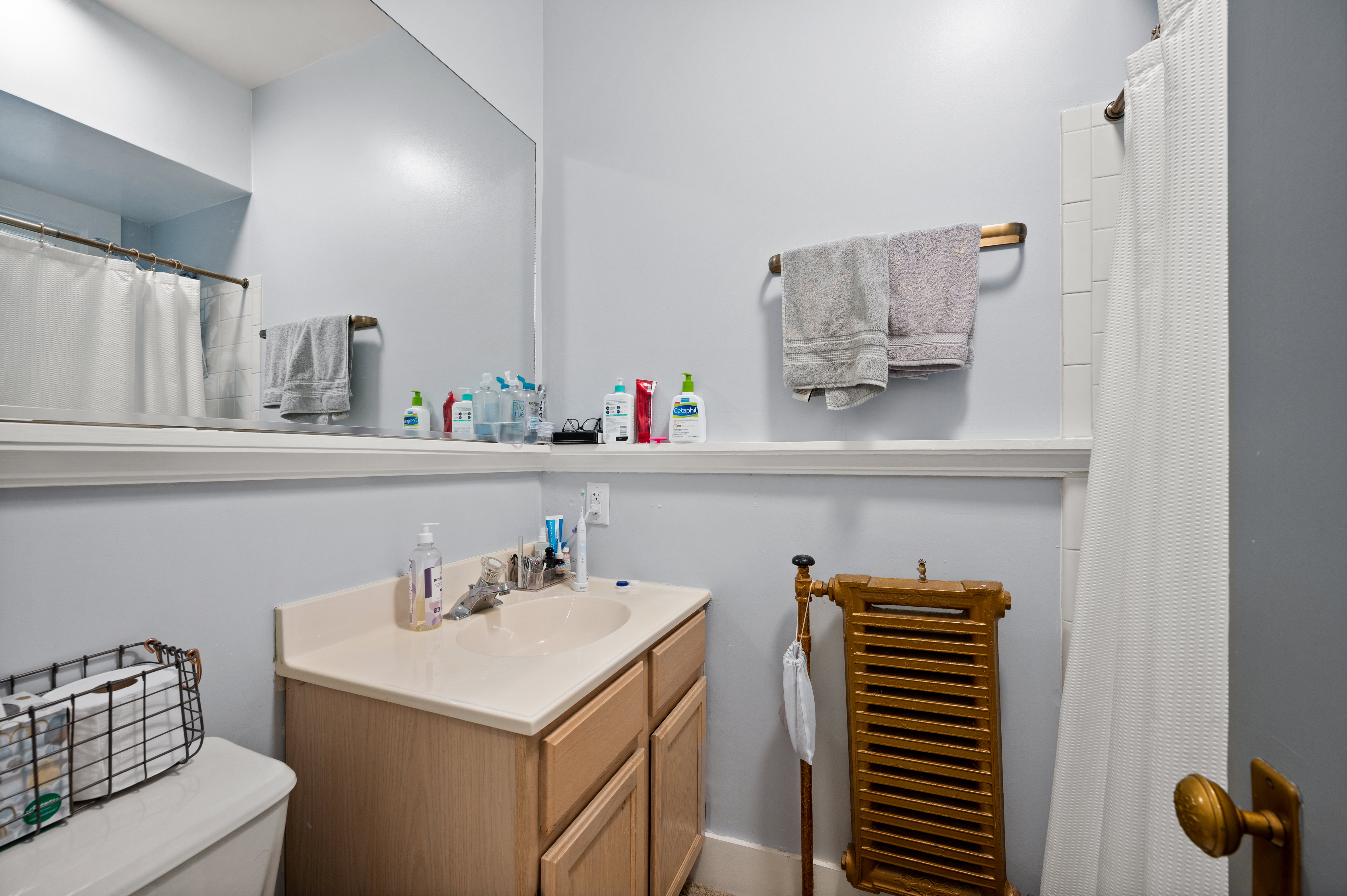Bathroom featuring a light wood-finish vanity with an integrated sink and countertop