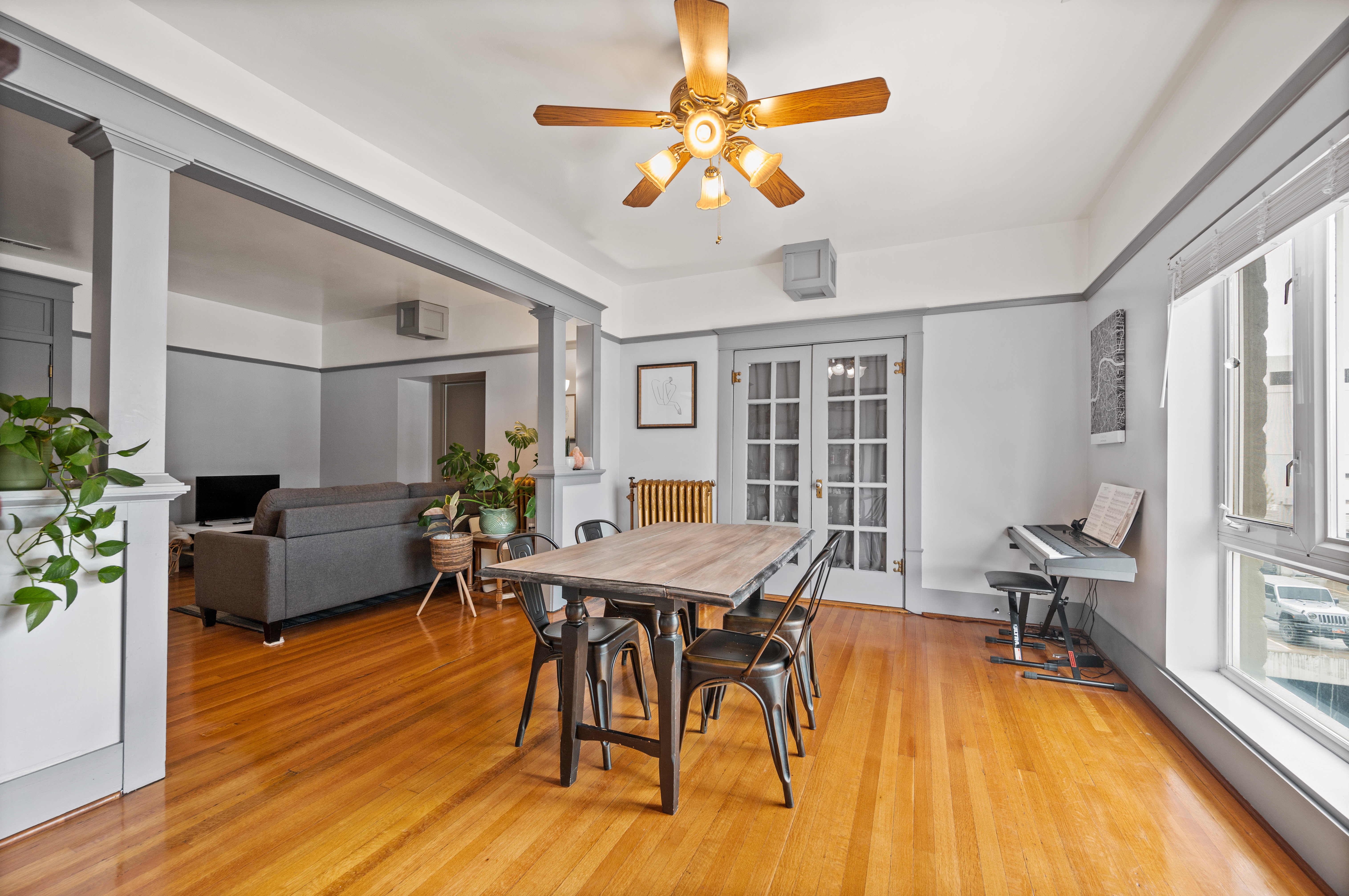 Hardwood flooring throughout featuring a wood-finish ceiling fan with integrated lighting