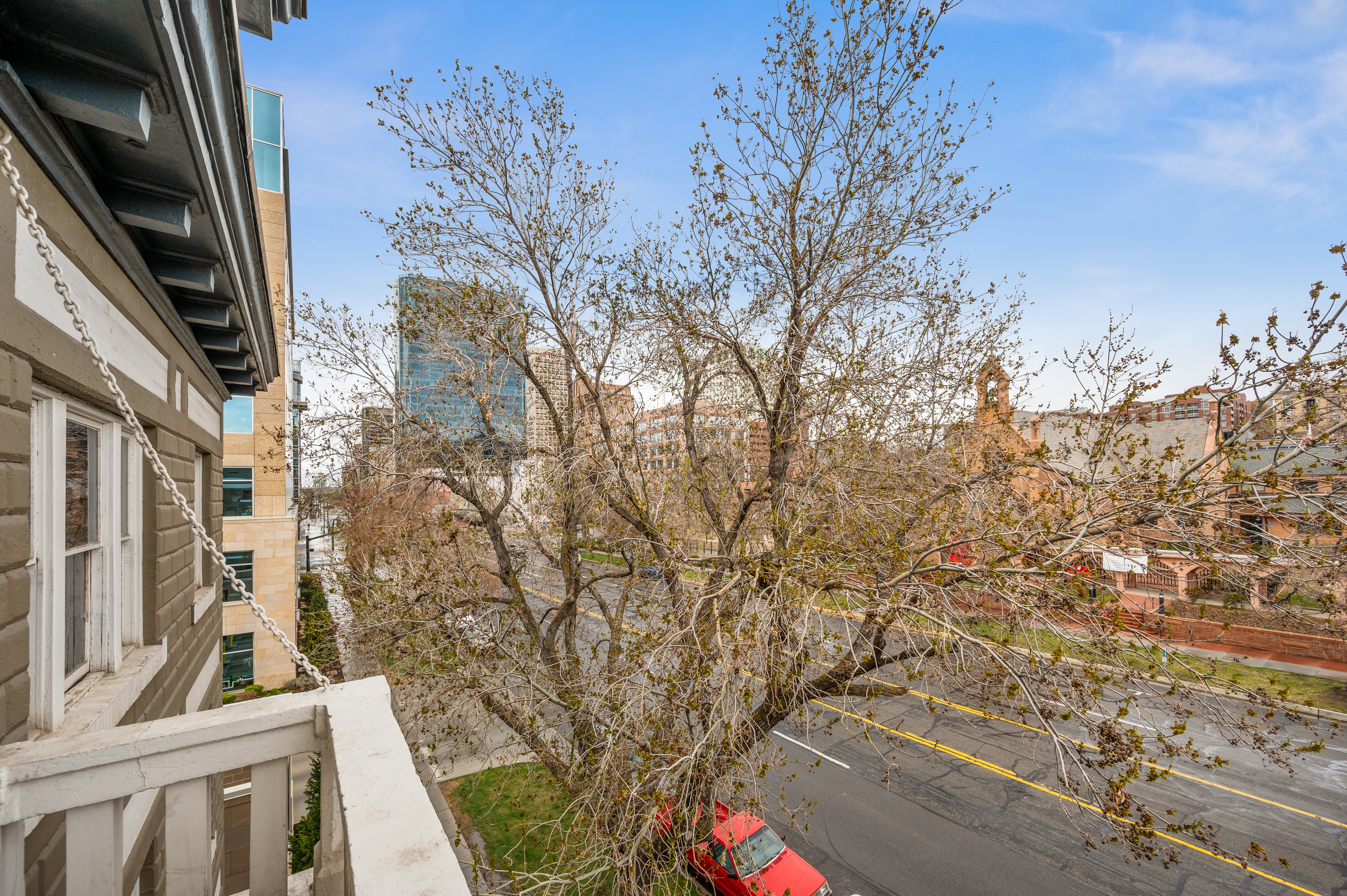 Exterior balcony with painted wood railing, offering a cityscape panorama