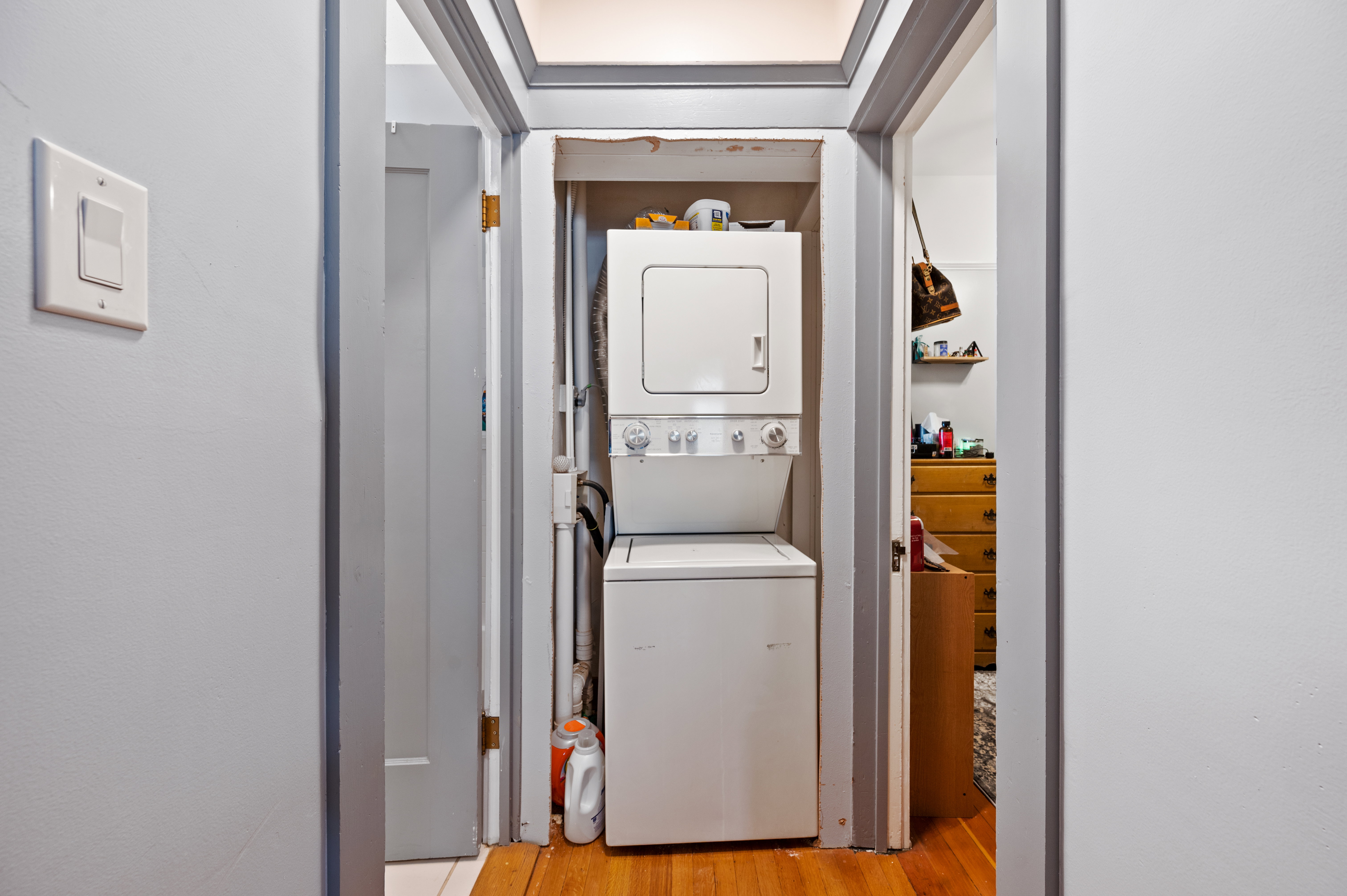 Dedicated laundry alcove featuring a stacked washer and dryer unit