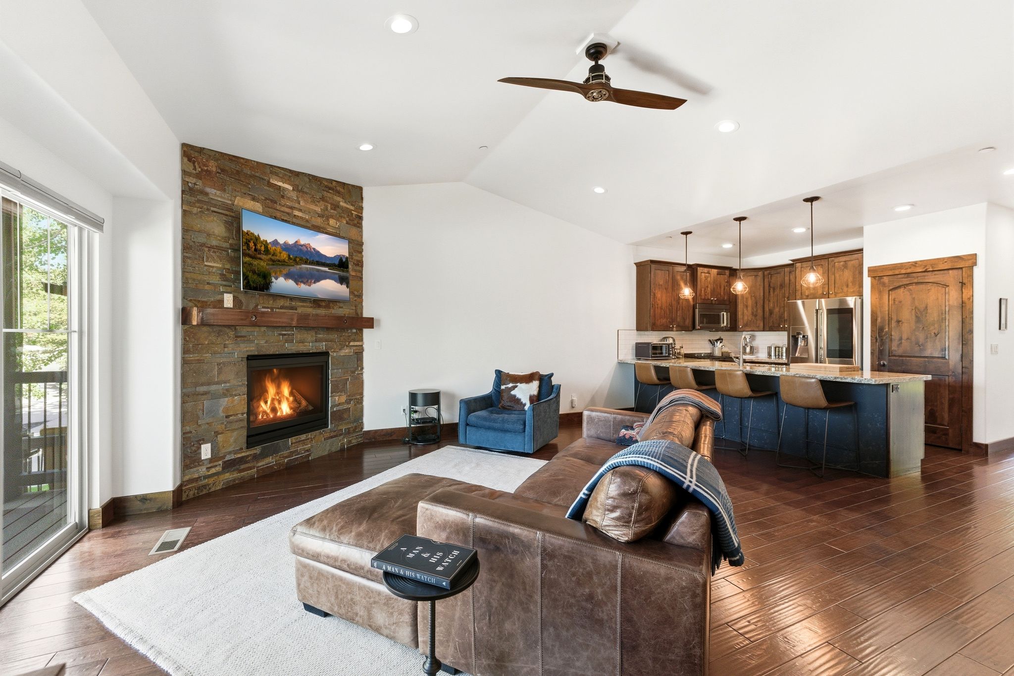 Open-concept living space featuring wood-finish flooring and a vaulted ceiling