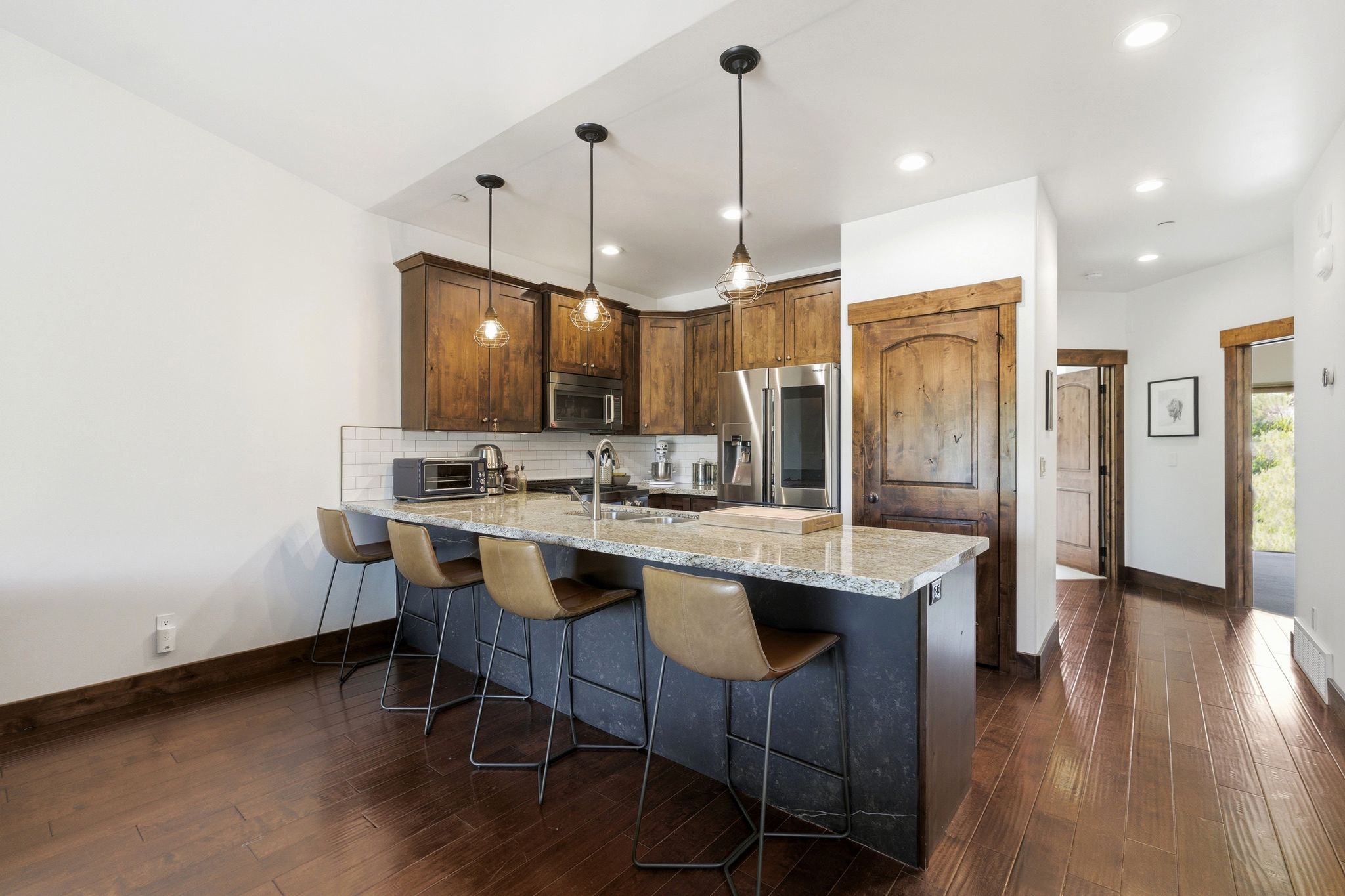 Kitchen featuring wood-finish flooring, recessed lighting, and a breakfast bar with pendant lighting