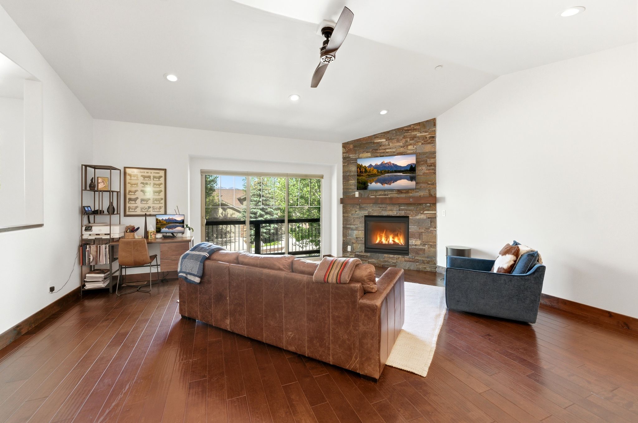 Spacious living area featuring rich wood-finish flooring, a vaulted ceiling, and recessed lighting