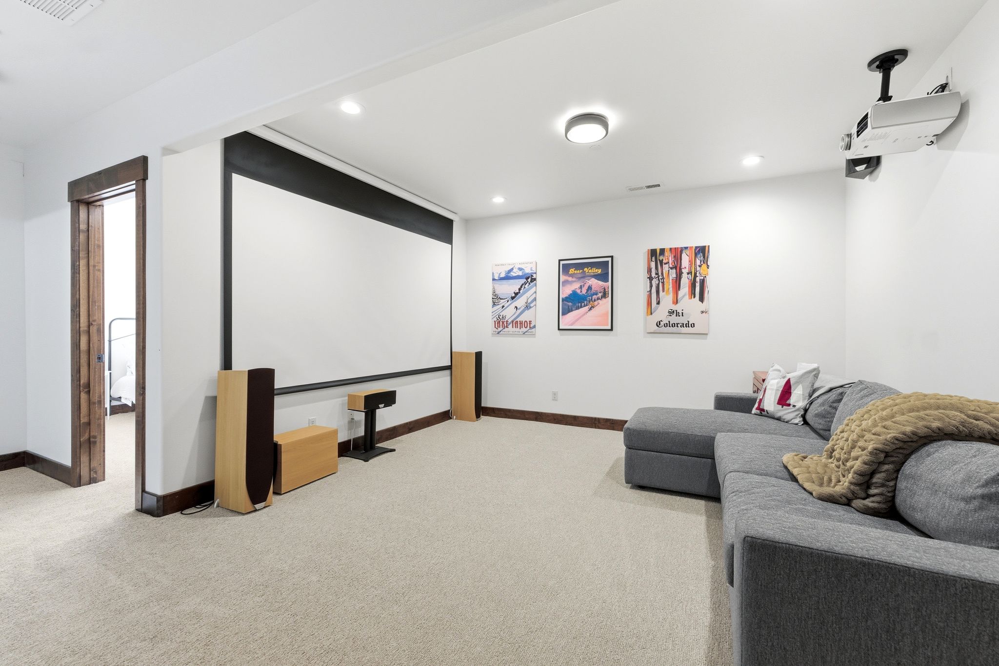 Entertainment room featuring a large projection screen, recessed lighting, and soft carpet flooring