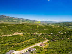 Expansive Lot 52, situated on a verdant hillside, offers a mountain backdrop and distant valley scenery