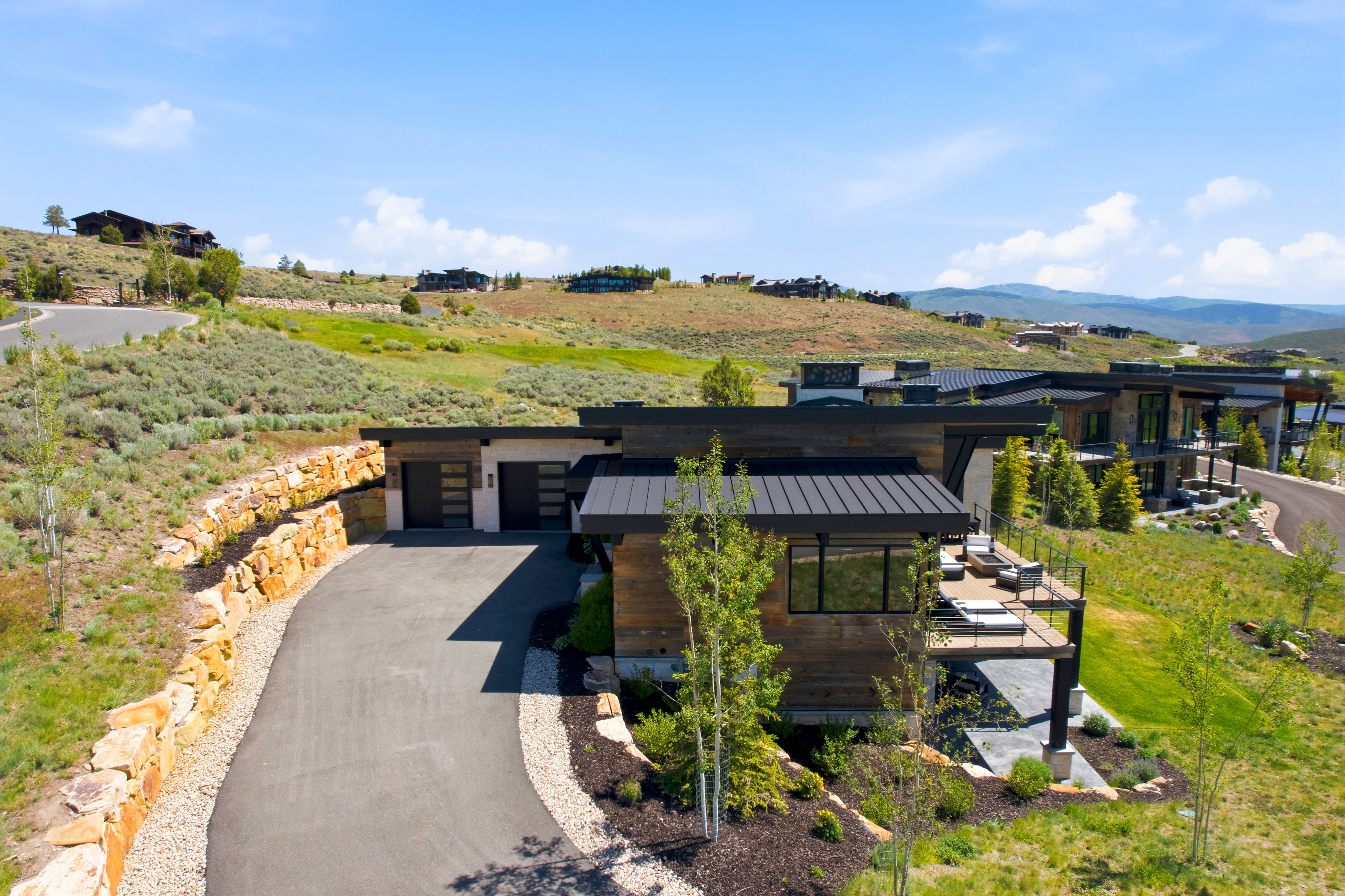 Modern mountain residence featuring a multi-level design, a prominent metal roof, and extensive wood-finish siding