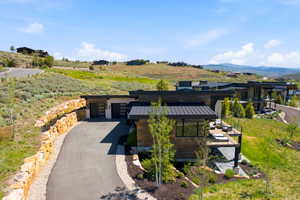 Modern mountain residence featuring a multi-level design, a prominent metal roof, and extensive wood-finish siding