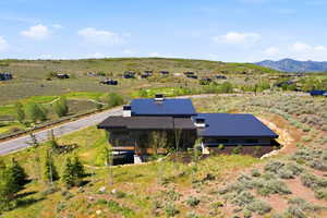 Modern-style residence featuring a dark metal roof, natural wood siding, and stone accents