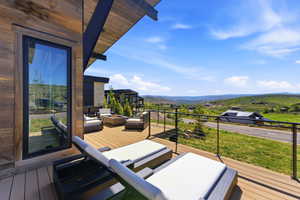 Expansive outdoor deck featuring wood-finish flooring, a contemporary cable railing system, and striking wood-paneled exterior siding