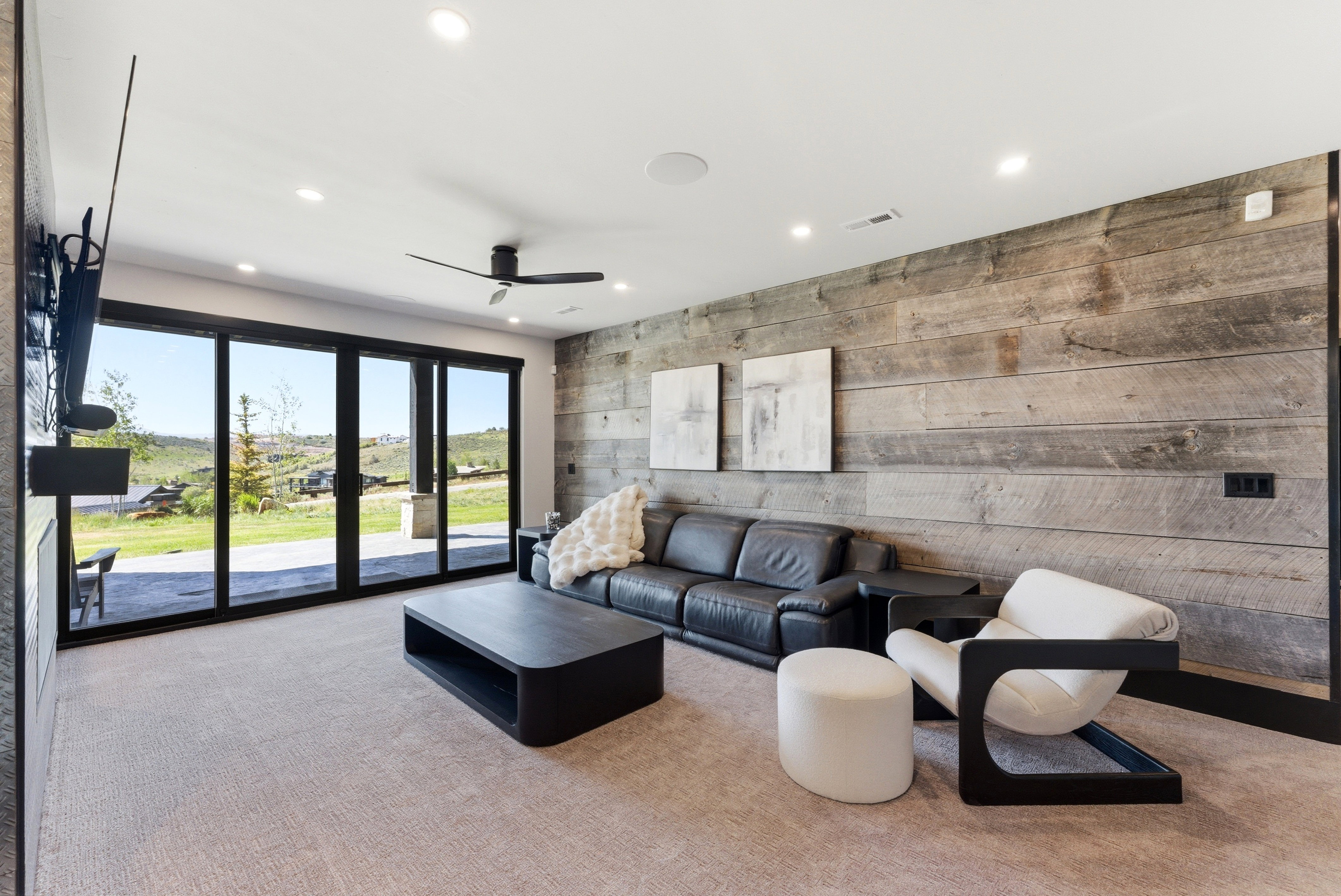 Spacious room featuring a full wall of sliding glass doors, recessed lighting, and a contemporary ceiling fan