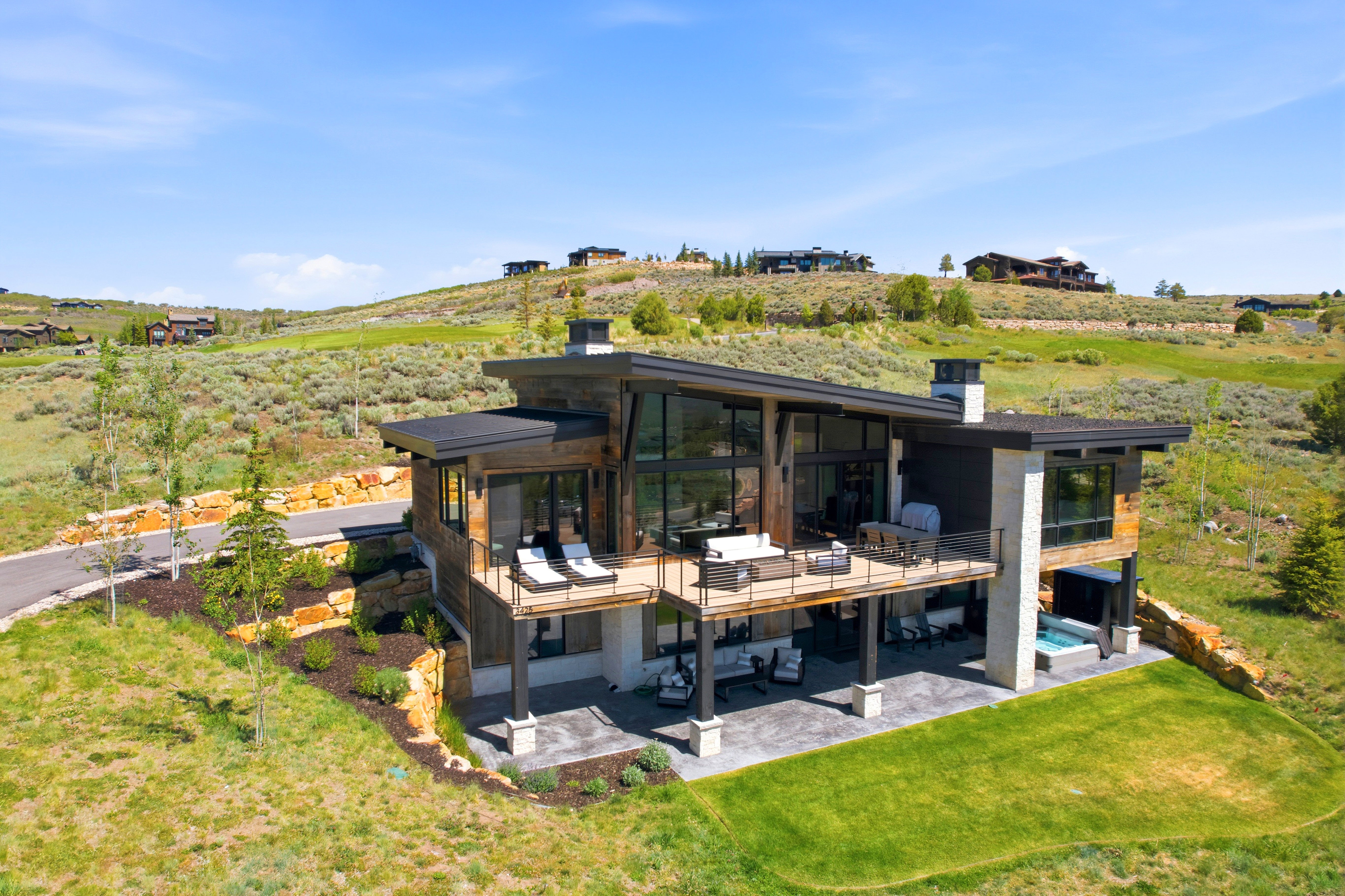 Contemporary mountain residence with extensive deck space, a lower patio, and an integrated hot tub