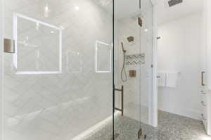 Walk-in shower featuring a frameless glass enclosure and herringbone tile walls