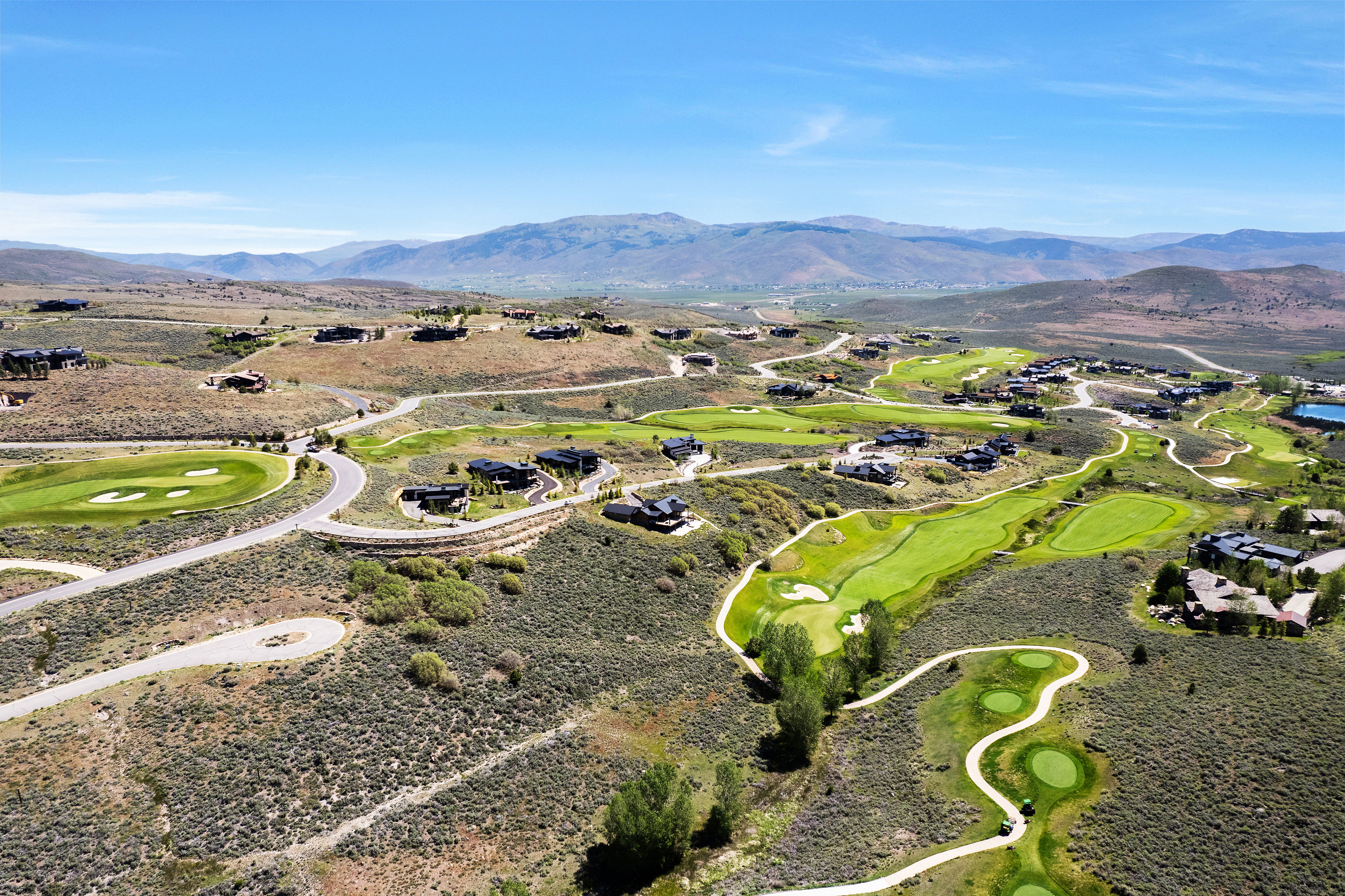 Expansive aerial perspective showcasing a golf course community with numerous fairways and greens