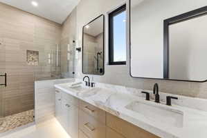 Double vanity featuring integrated sinks, matte black fixtures, and a marbled countertop