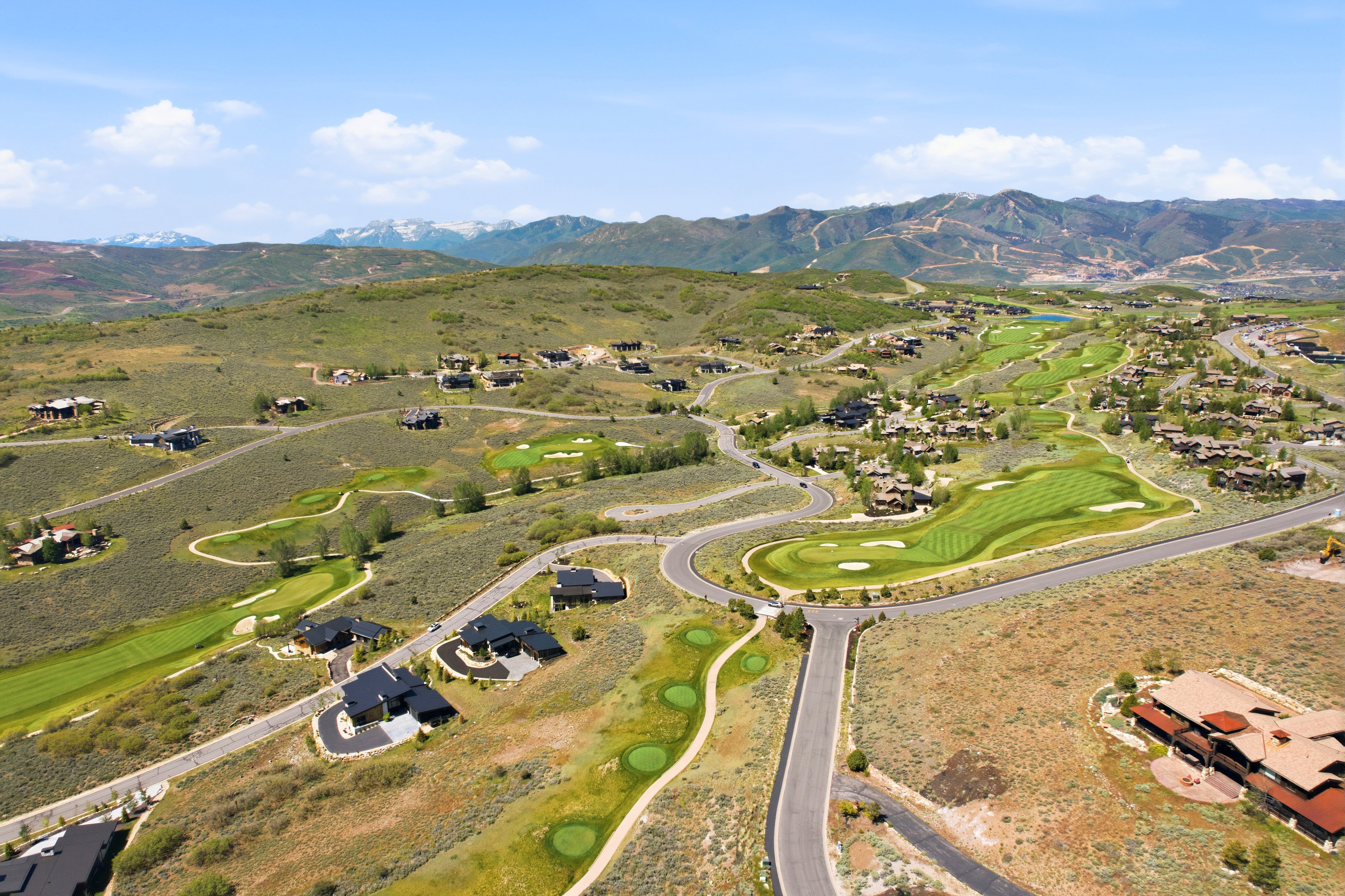 Expansive aerial showcasing a golf course community with mountain scenery