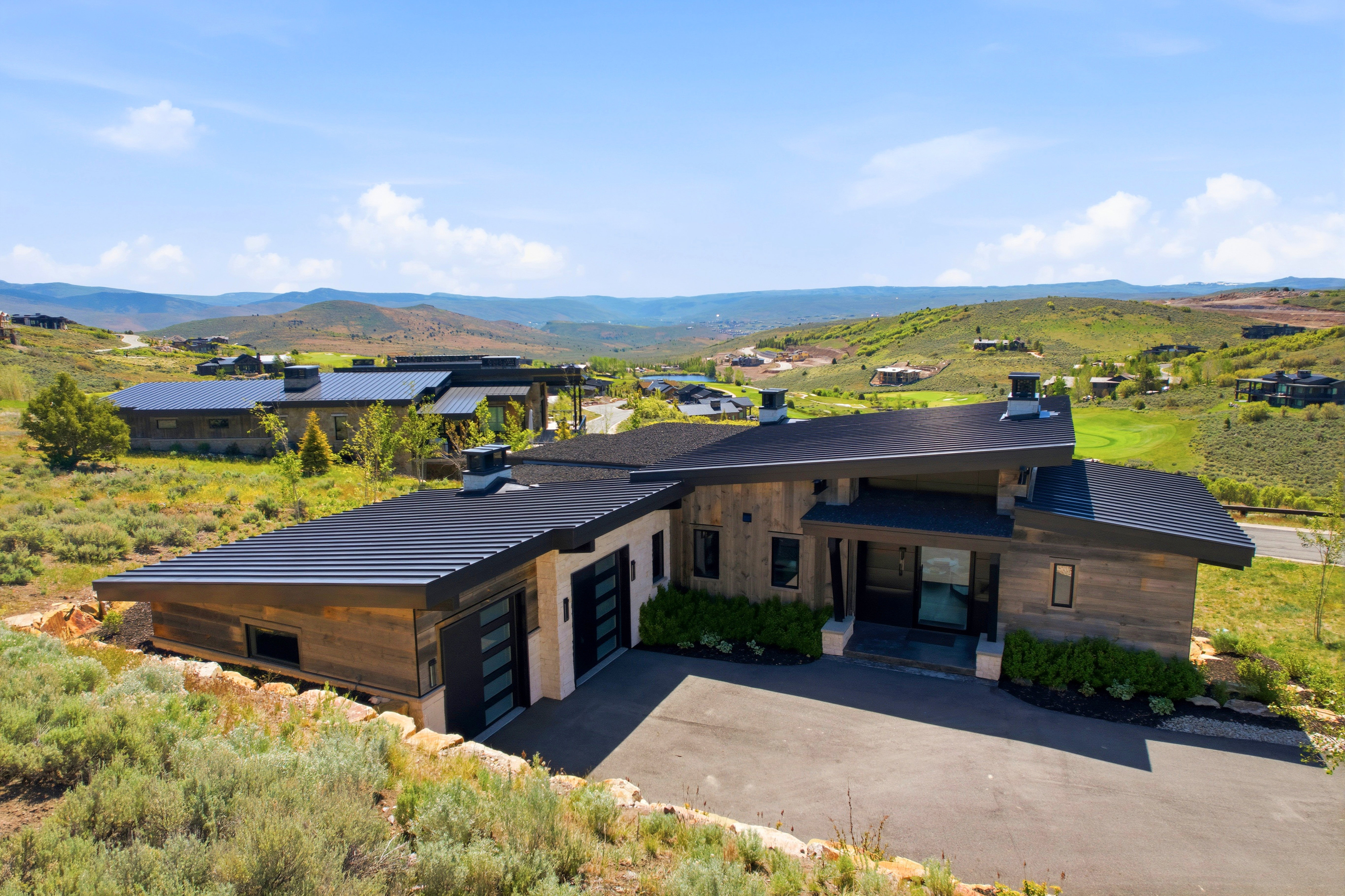 Modern architectural residence featuring a sloped roofline and extensive wood-finish siding