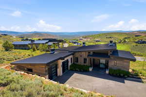 Modern architectural residence featuring a sloped roofline and extensive wood-finish siding