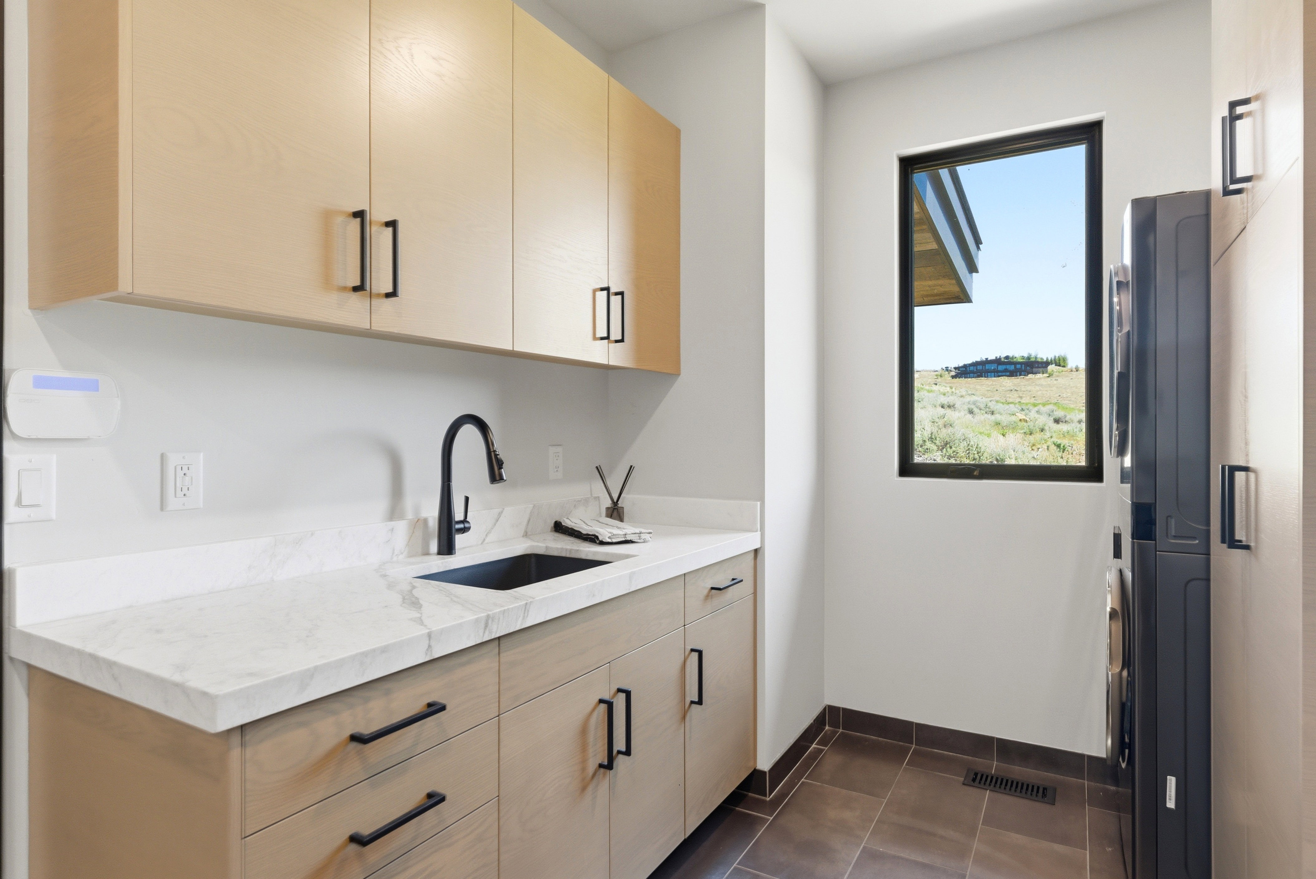Laundry area featuring a large window with desert scenery