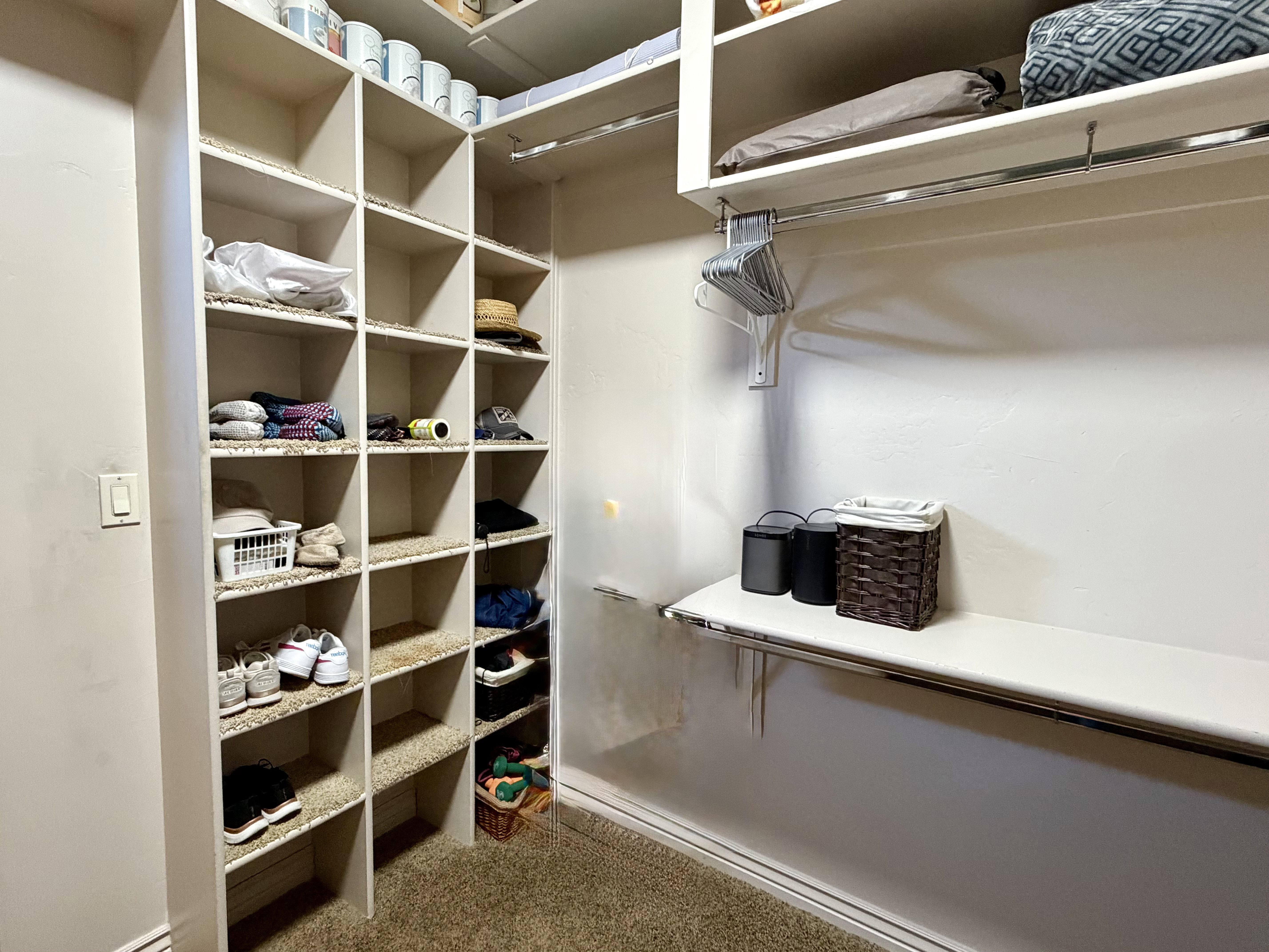 Custom Master closet system with extensive built-in shelving, multiple hanging rods, and a lower built-in surface
