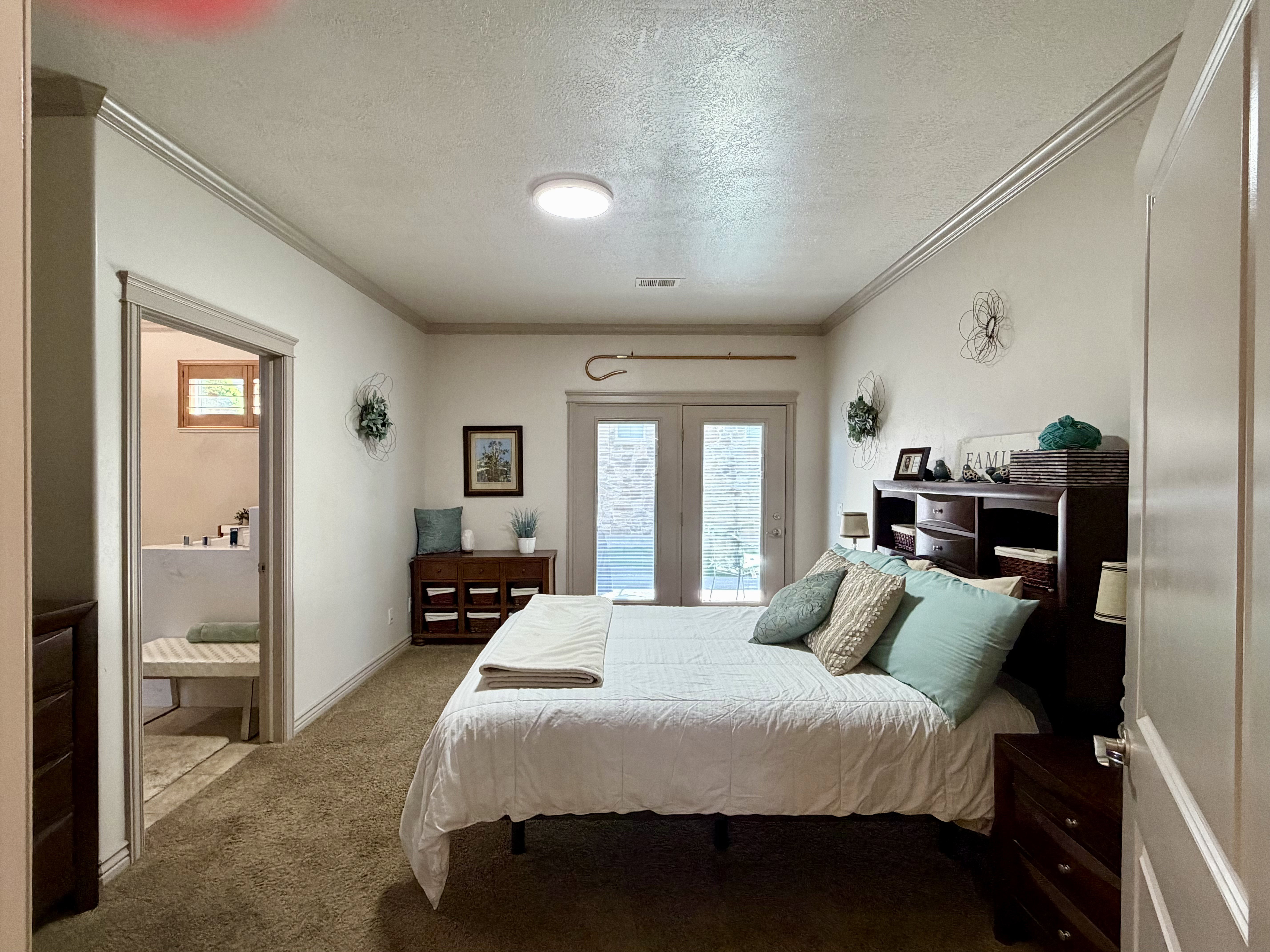 This spacious master bedroom offered plenty of room for a king-sized bed, has easy access to a private patio, and connects to a large en-suite bathroom with double vanity and a walk-in closet