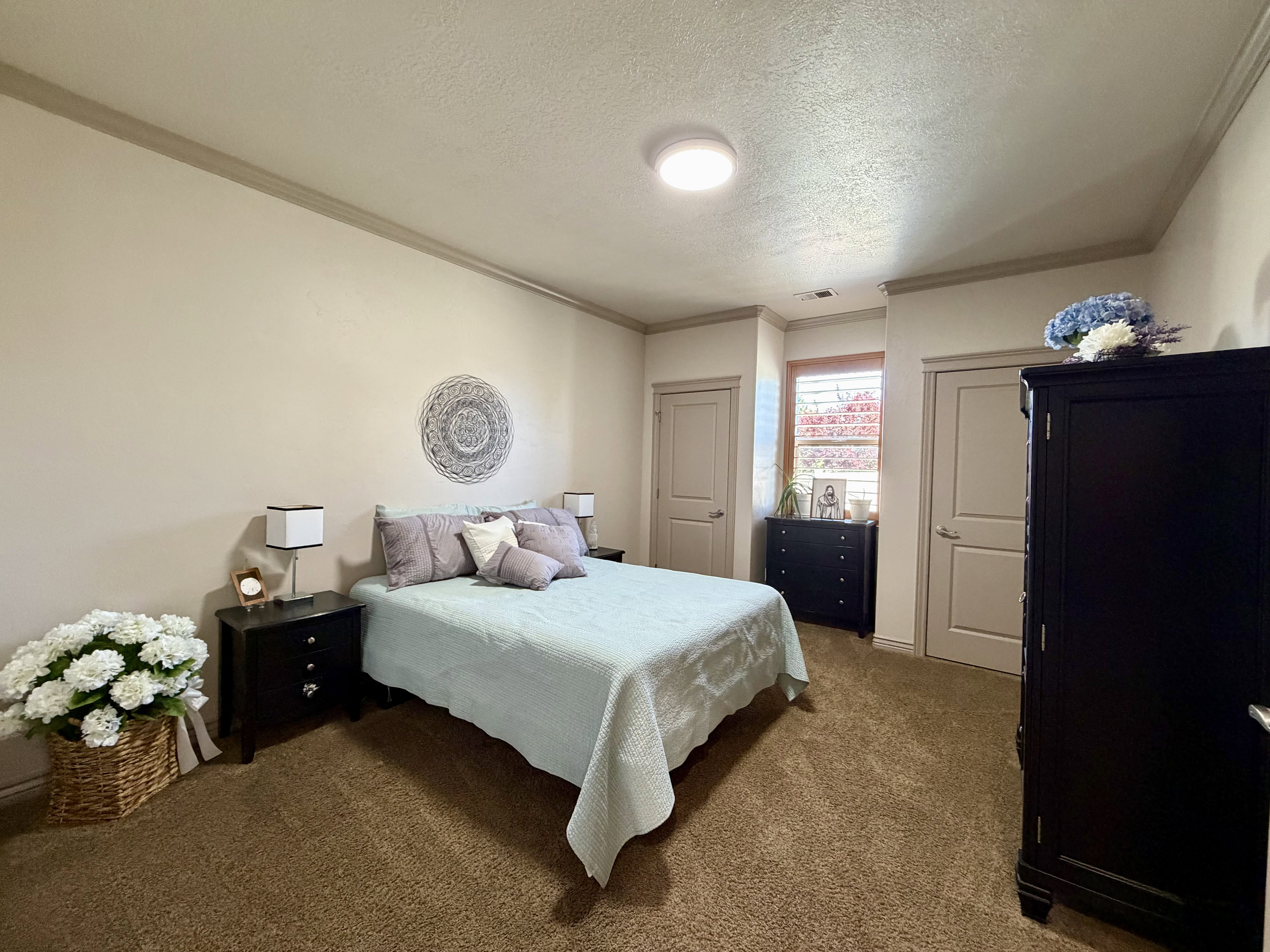 Generously sized bedroom is bright and open with two closets featuring crown molding.
