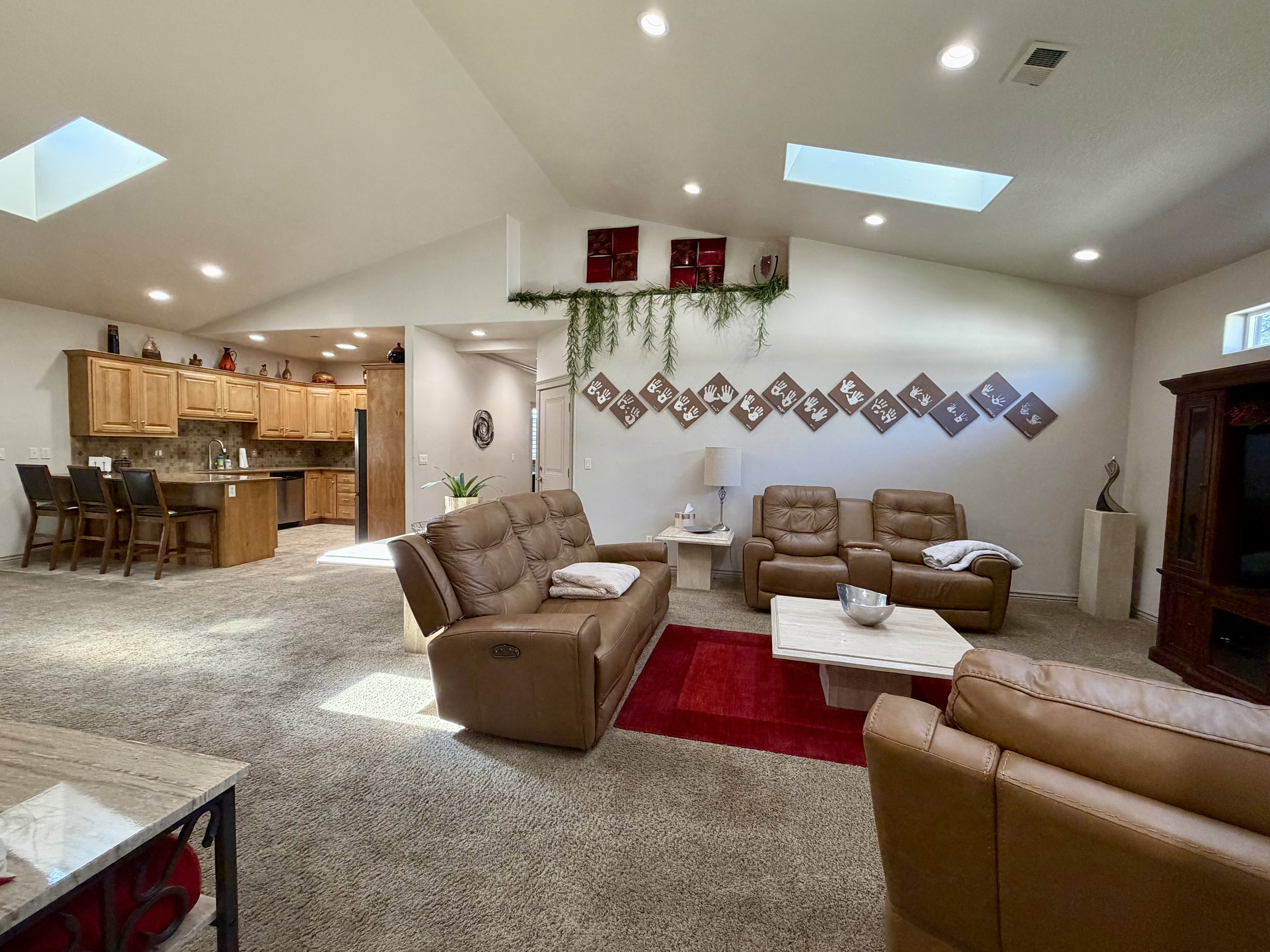Vaulted ceilings with multiple skylights and recessed lighting illuminate this spacious great room designed for both comfort and connection.
