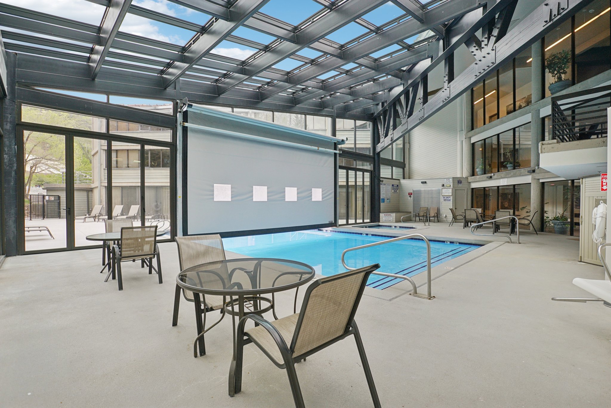 Indoor swimming pool with an overhead glass and metal roof structure