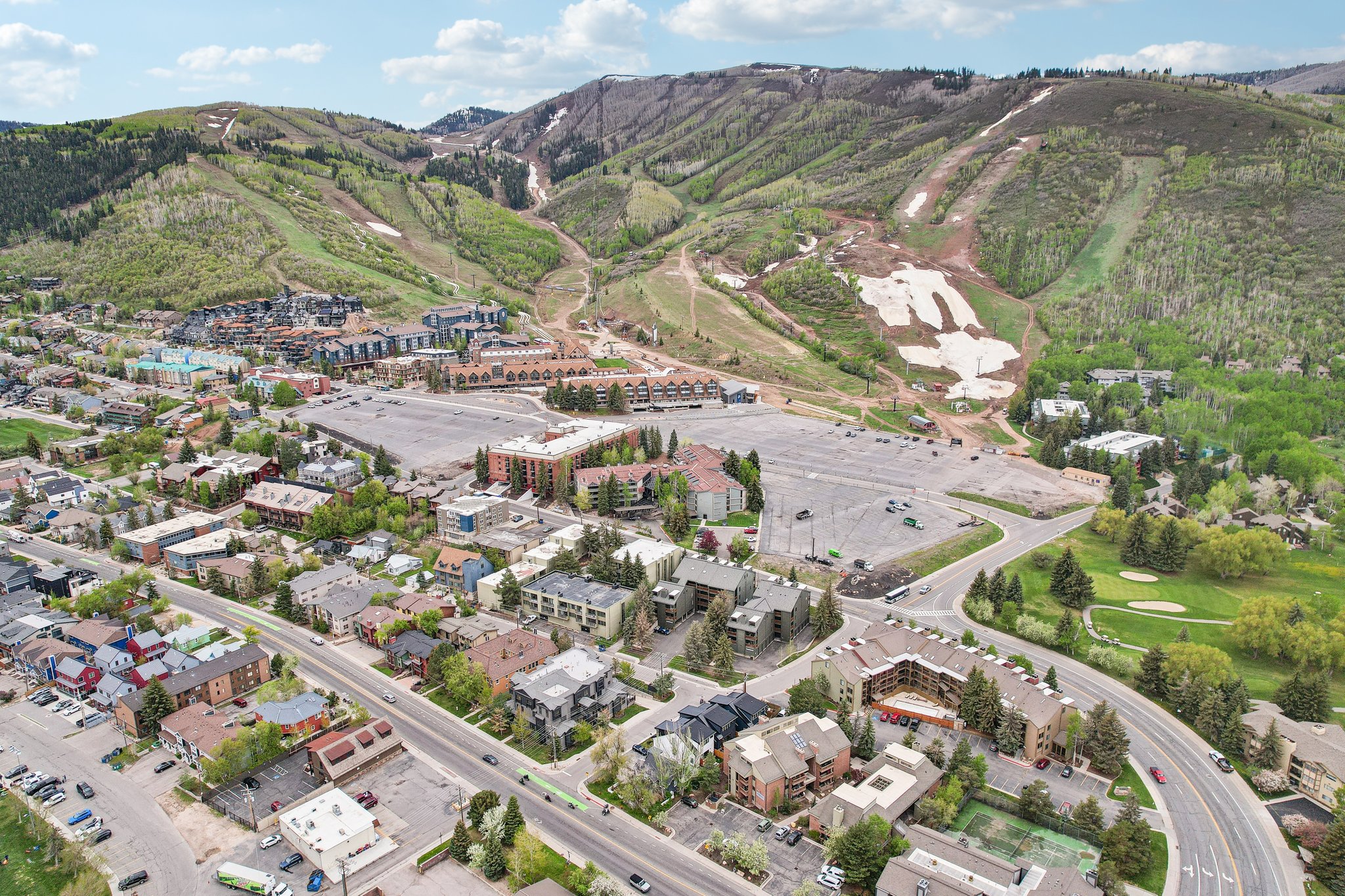 Mountainous terrain backdrop featuring varied slopes with visible ski runs and remnants of snow