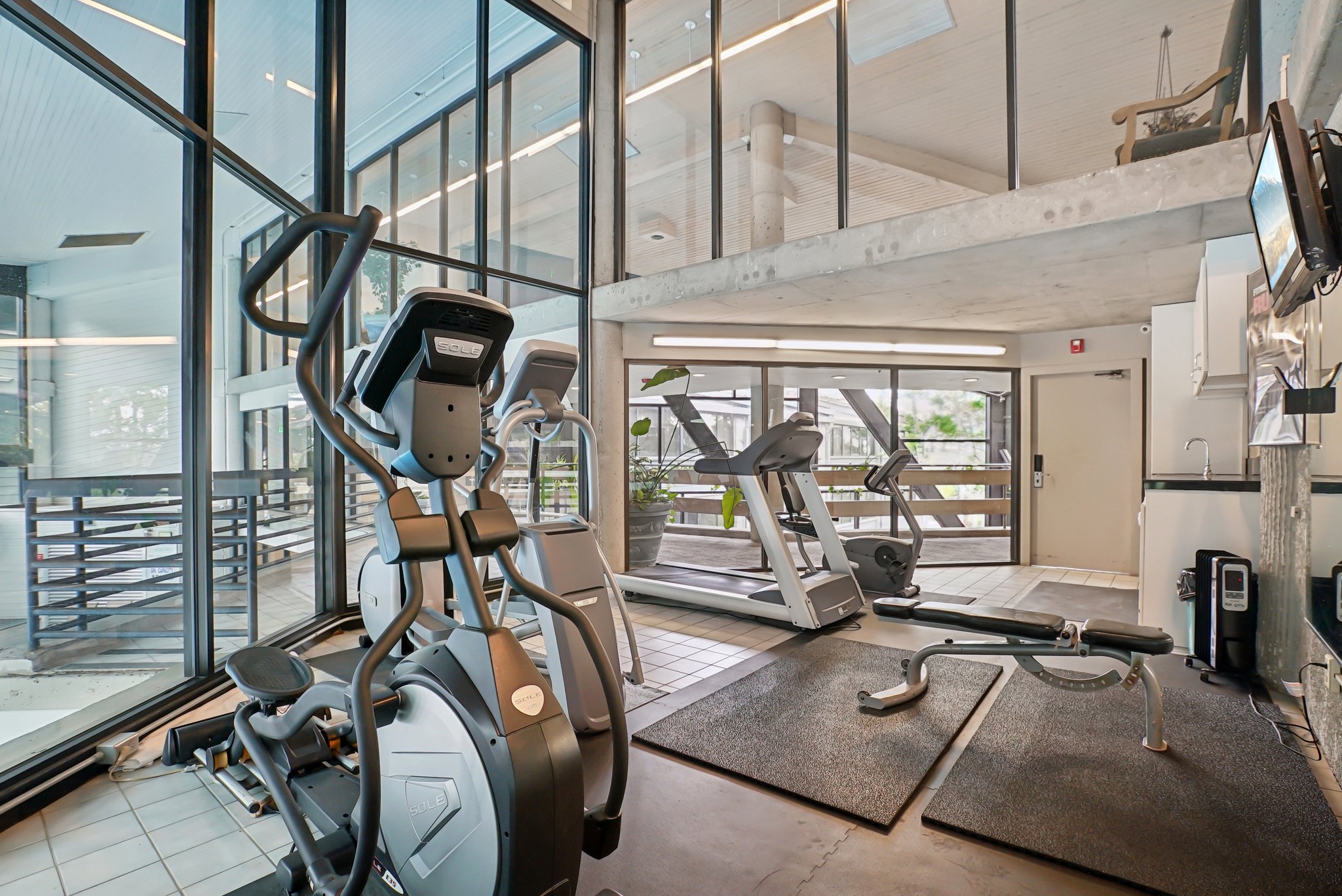 Fitness center with a selection of cardio equipment, including an elliptical, treadmill, and exercise bike