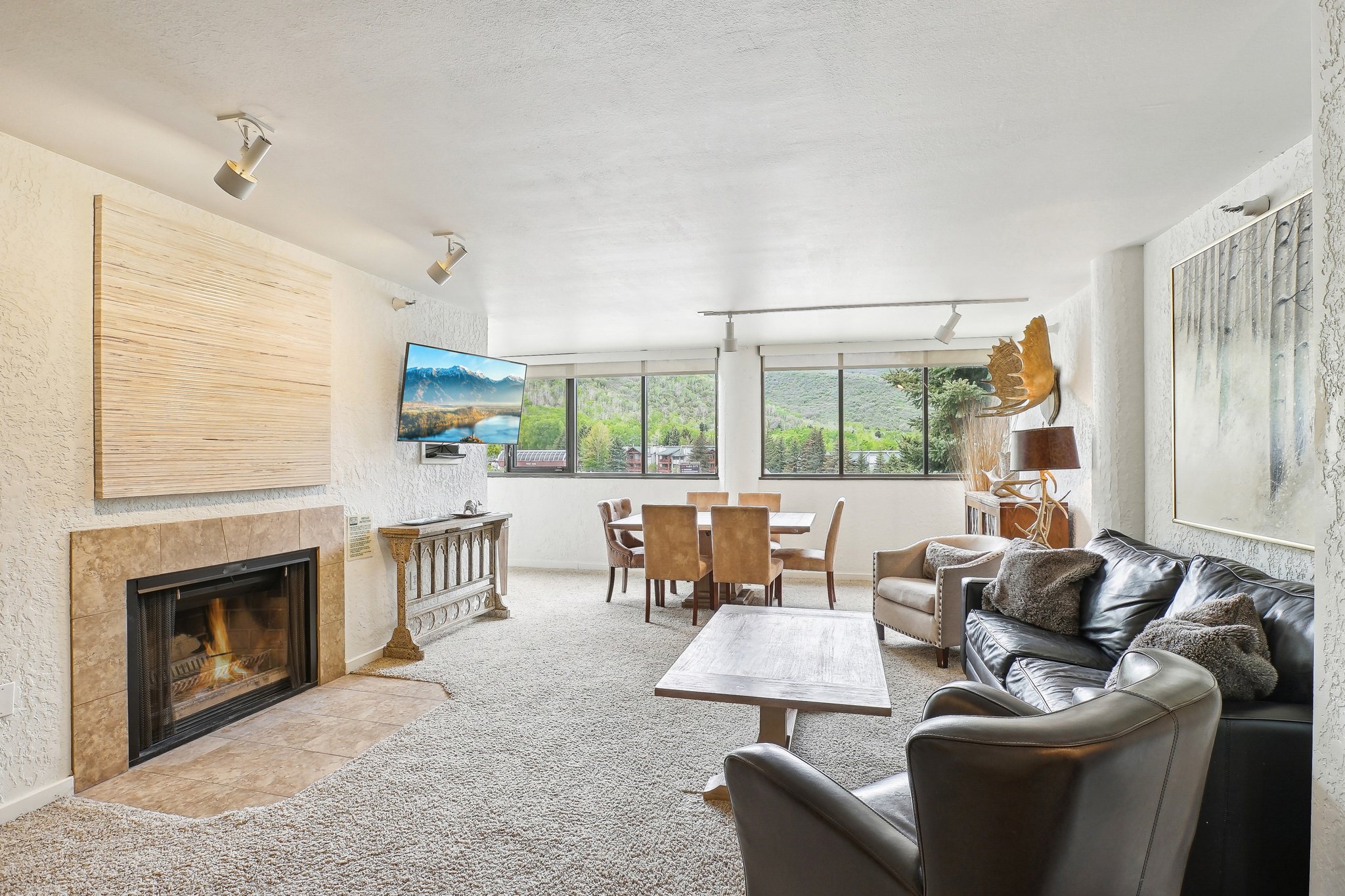 Open living area with a built-in fireplace featuring a stone surround and hearth