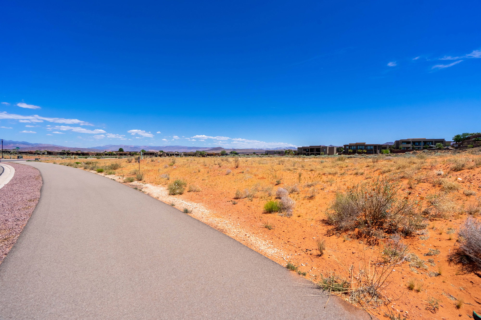 Paved pathway alongside undeveloped land