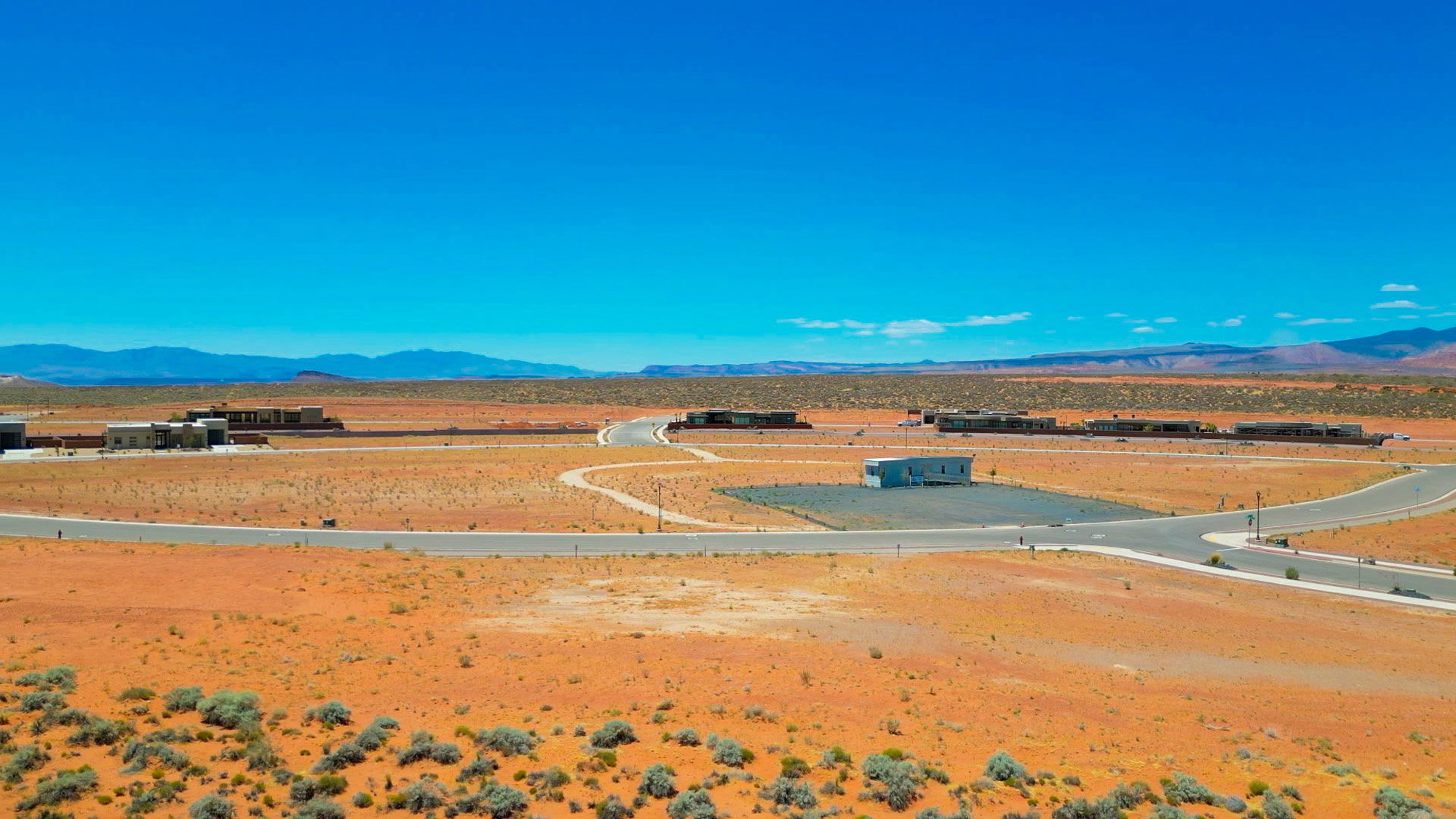 Expansive desert landscape with multiple building pads and paved roads