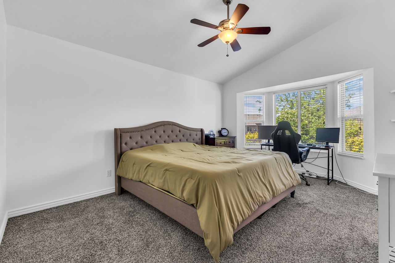 Room featuring a vaulted ceiling and a ceiling fan with integrated lighting