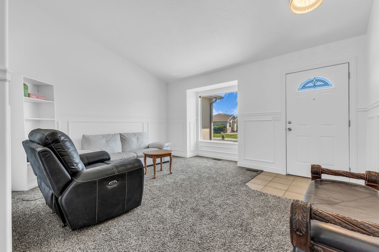Spacious living area featuring high vaulted ceilings, wainscoting details, and built-in shelving