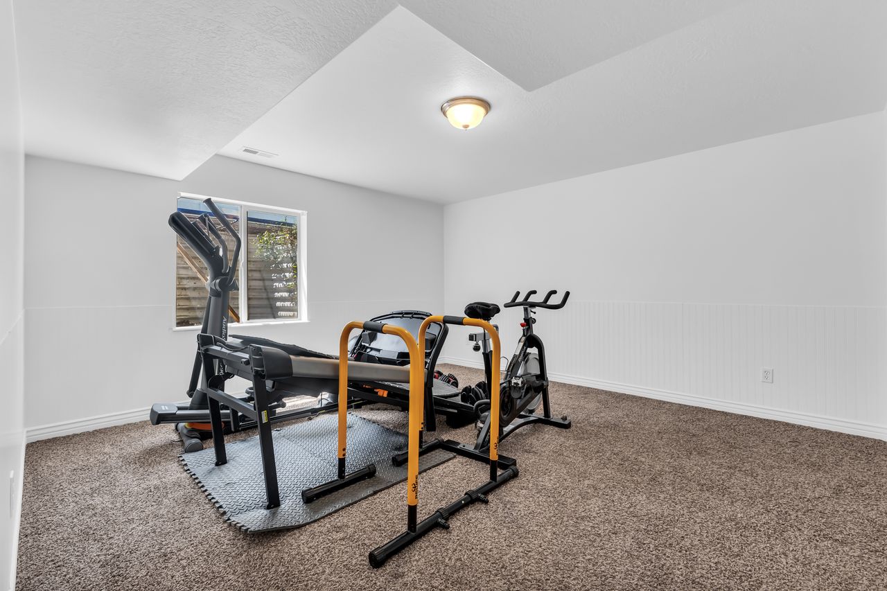 Carpeted room with white walls, a recessed window, and white beadboard paneling