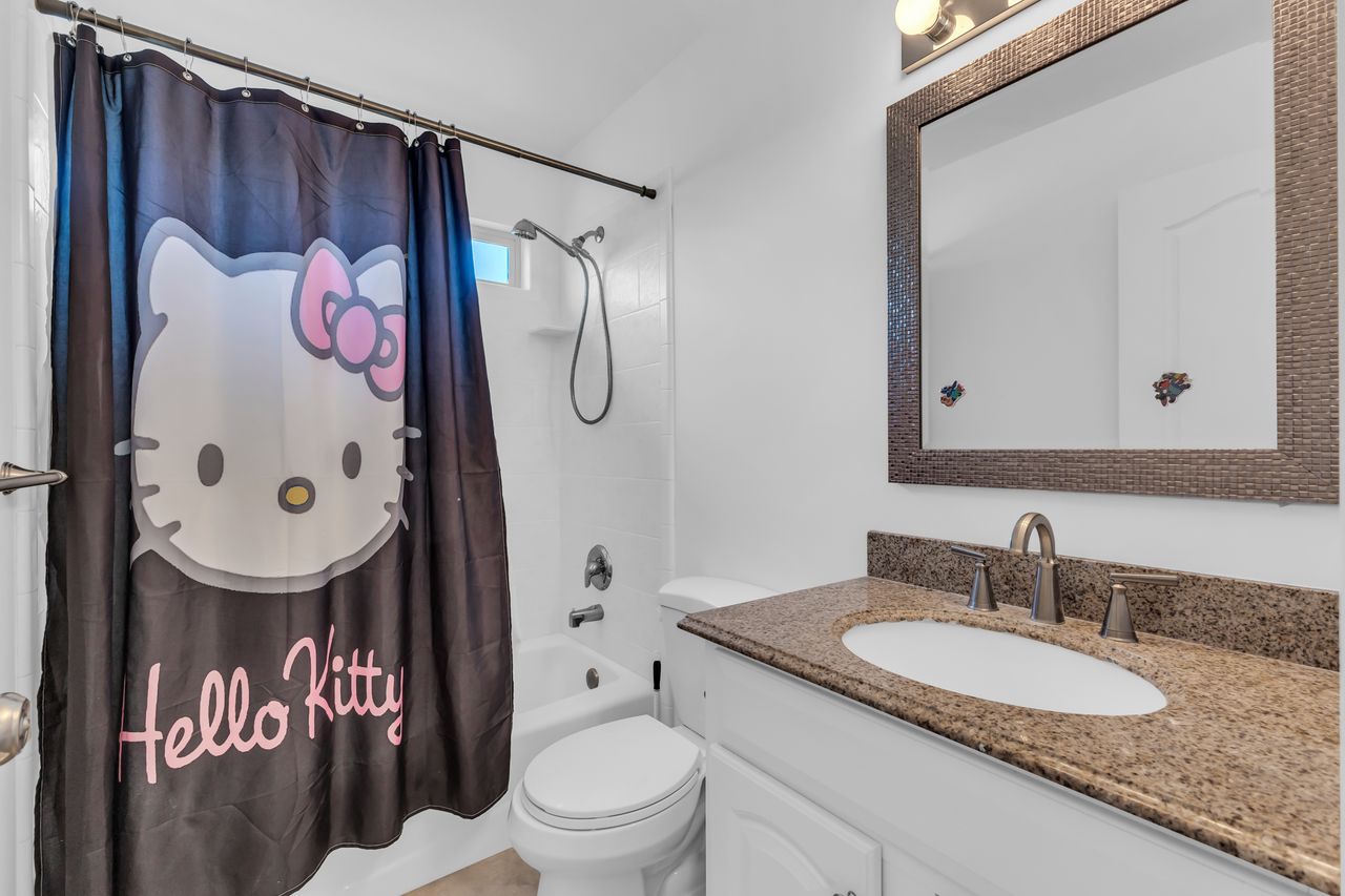 Bathroom featuring a combination shower and tub with white subway tile surround, a built-in shelf, and a window for natural light