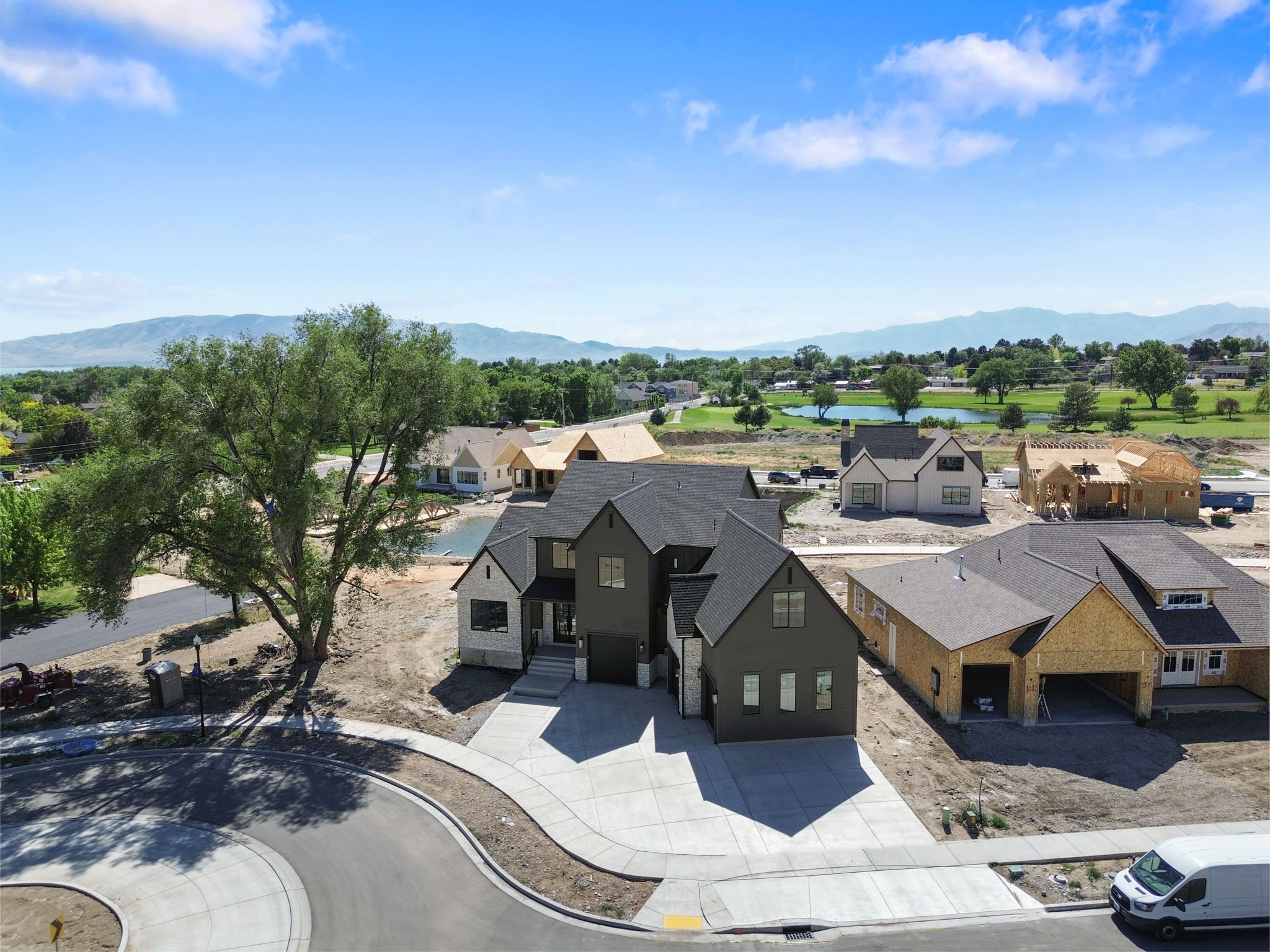 Contemporary multi-story residence featuring a dark-toned exterior with stone accents and a prominent two-car garage