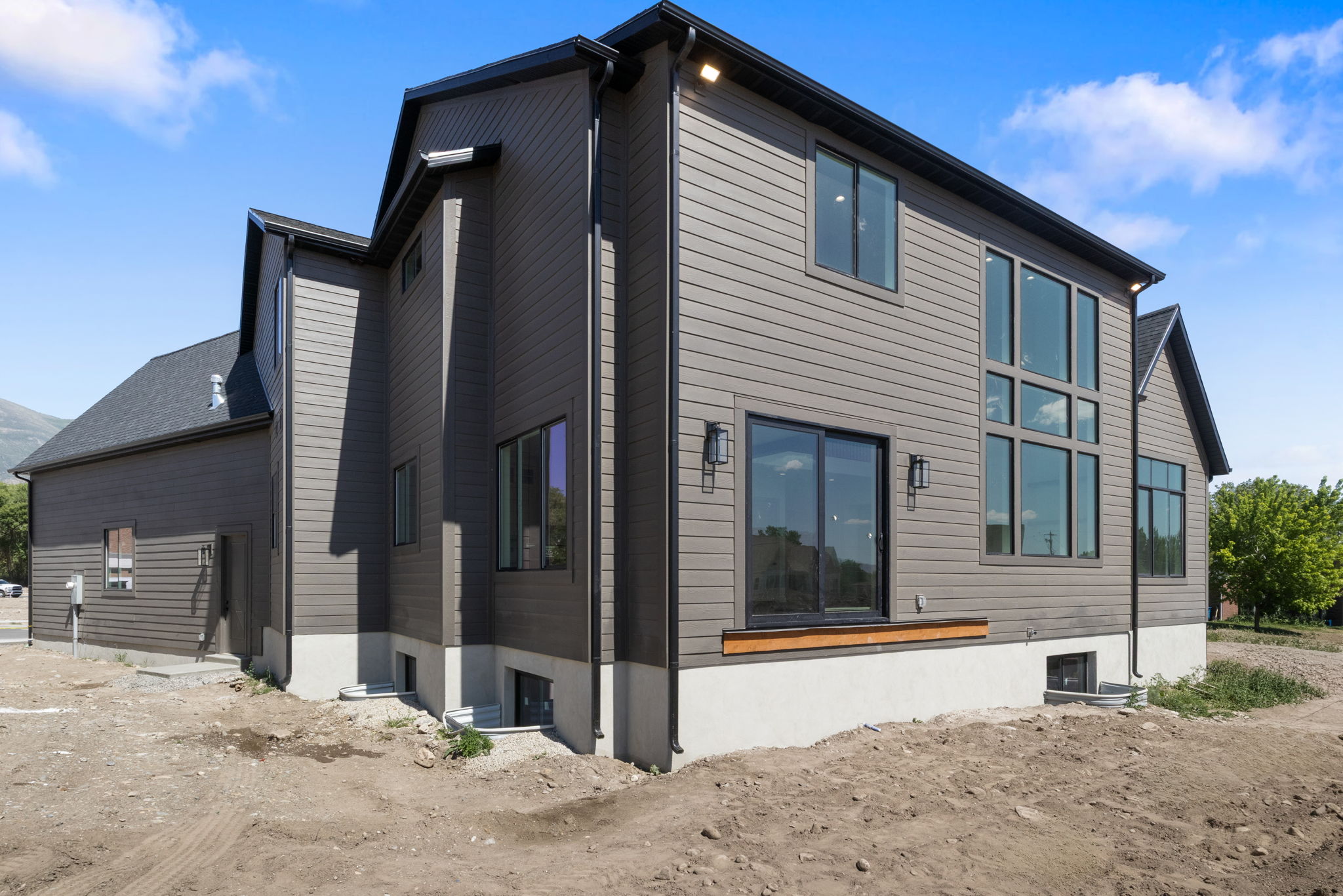 Modern exterior featuring gray horizontal siding and a dark shingle roof