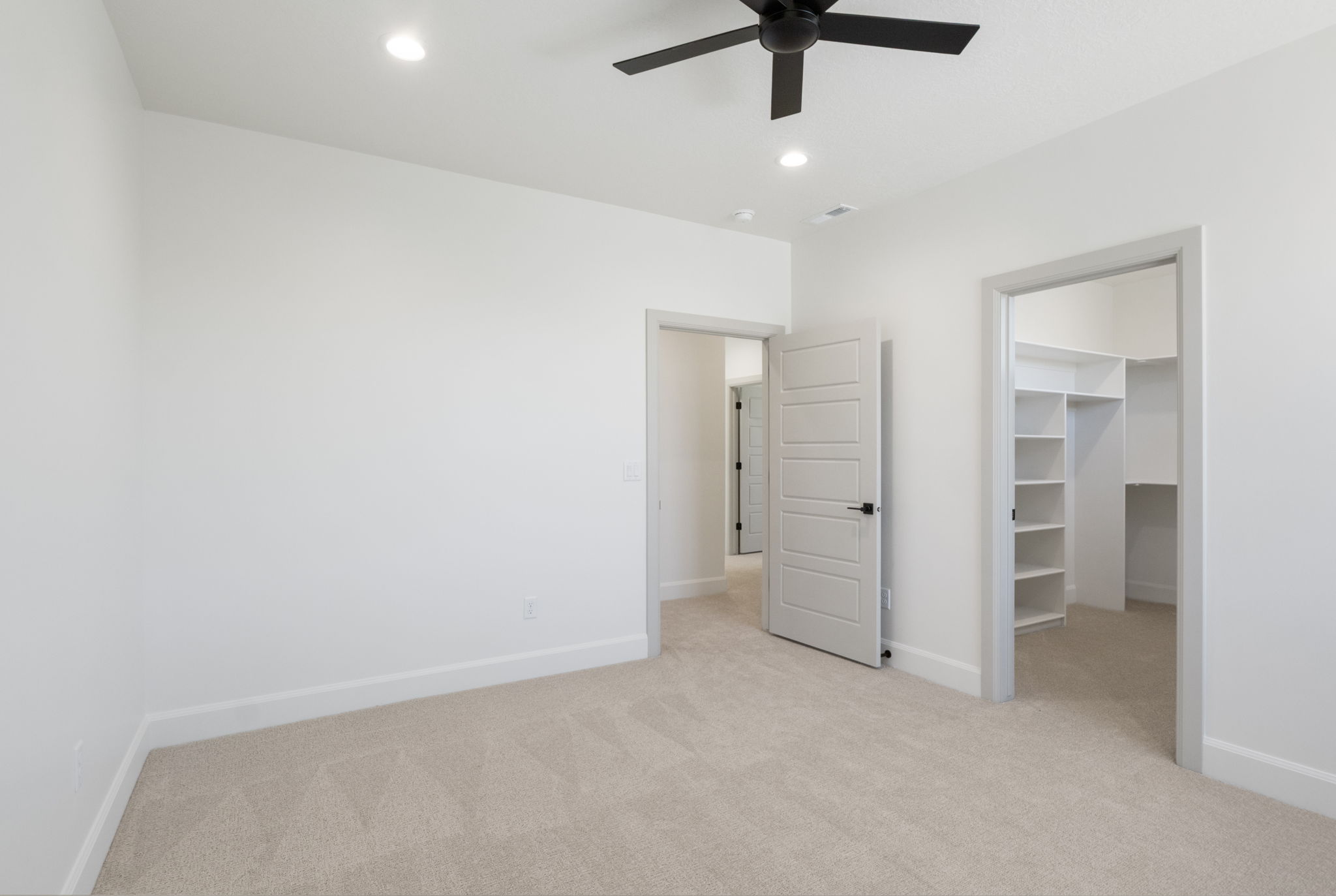 Carpeted room with recessed lighting and a black ceiling fan