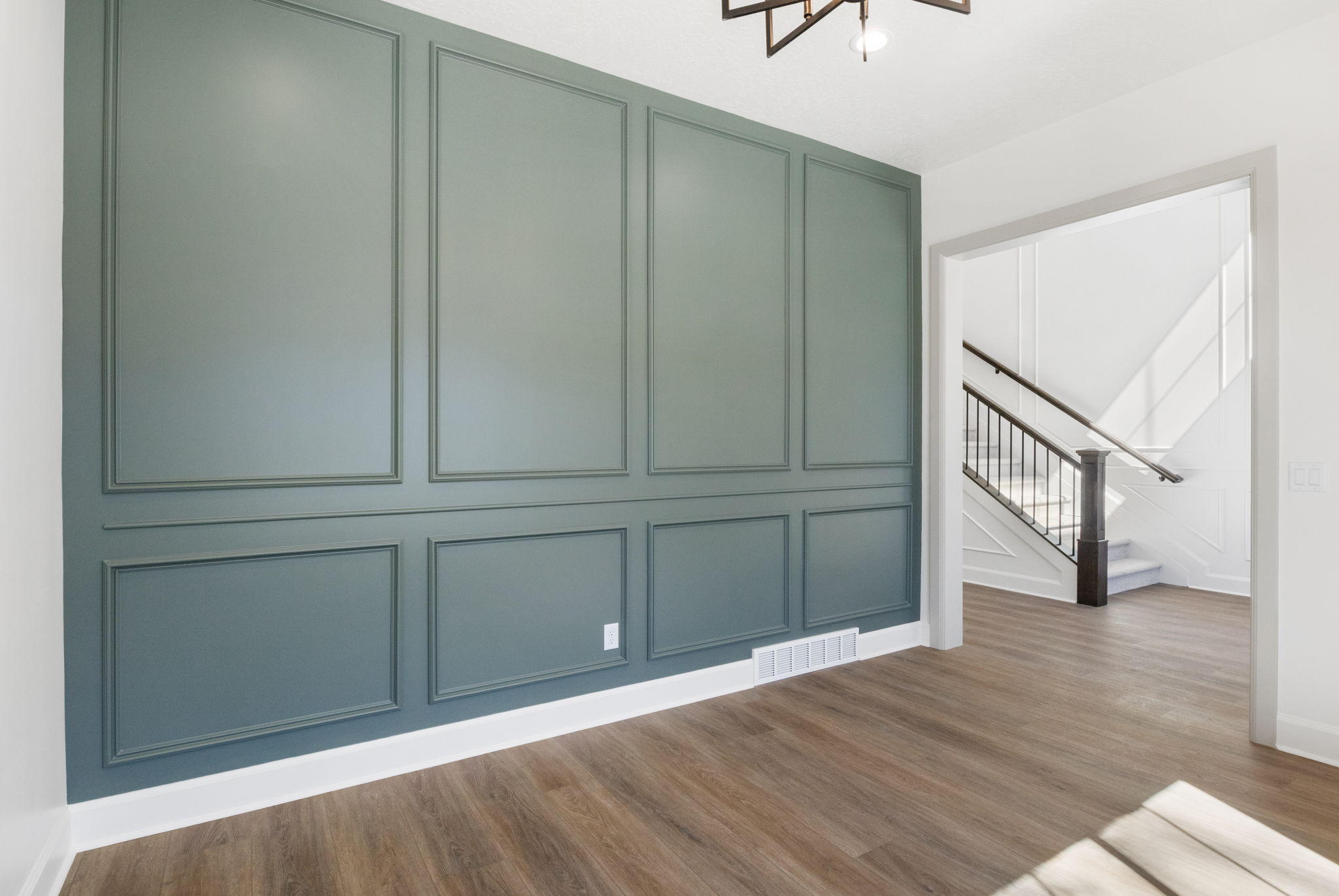 Accent wall featuring decorative molding and a deep teal finish