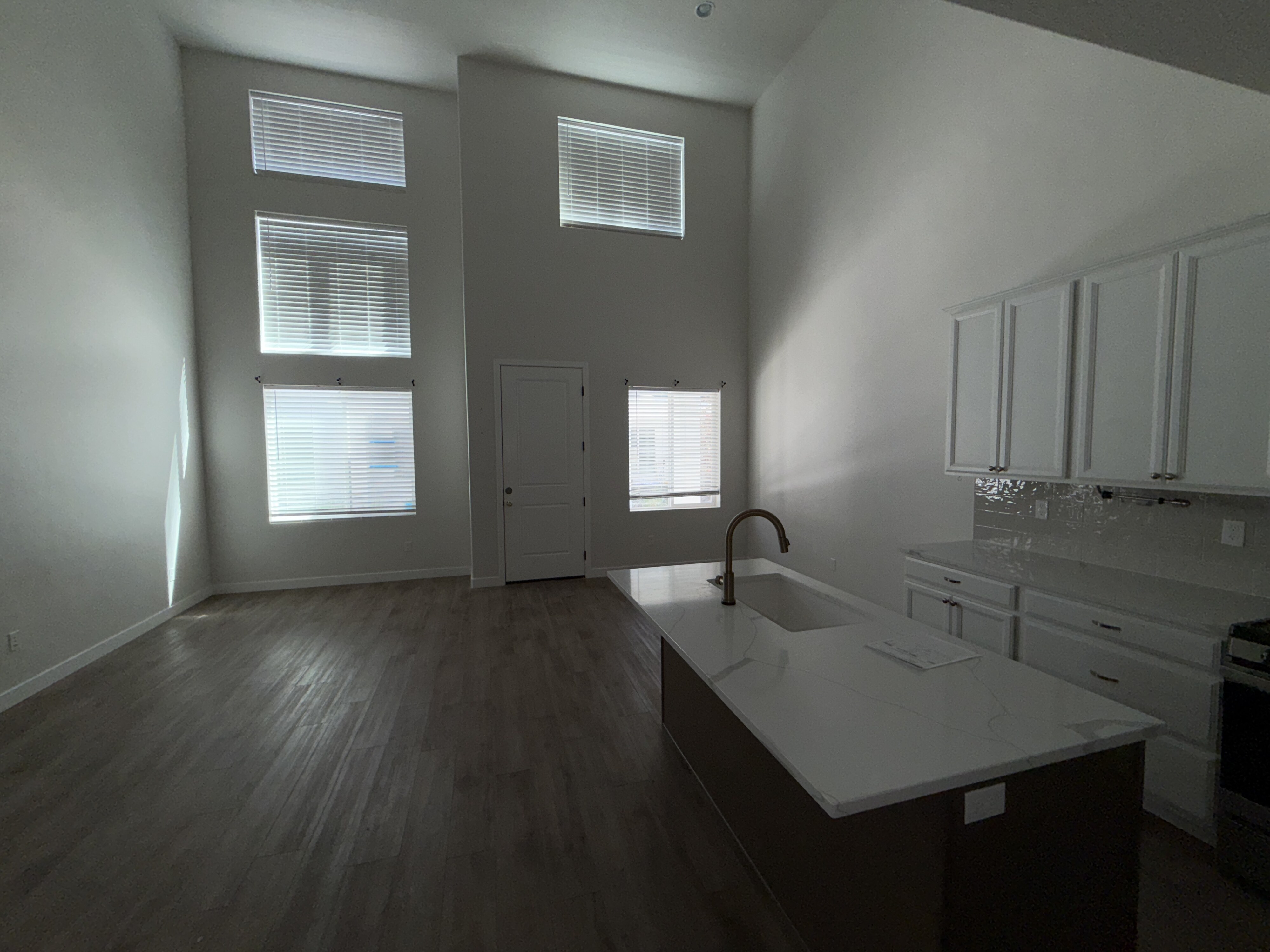 Open-concept living area with soaring ceilings and wood-finish flooring