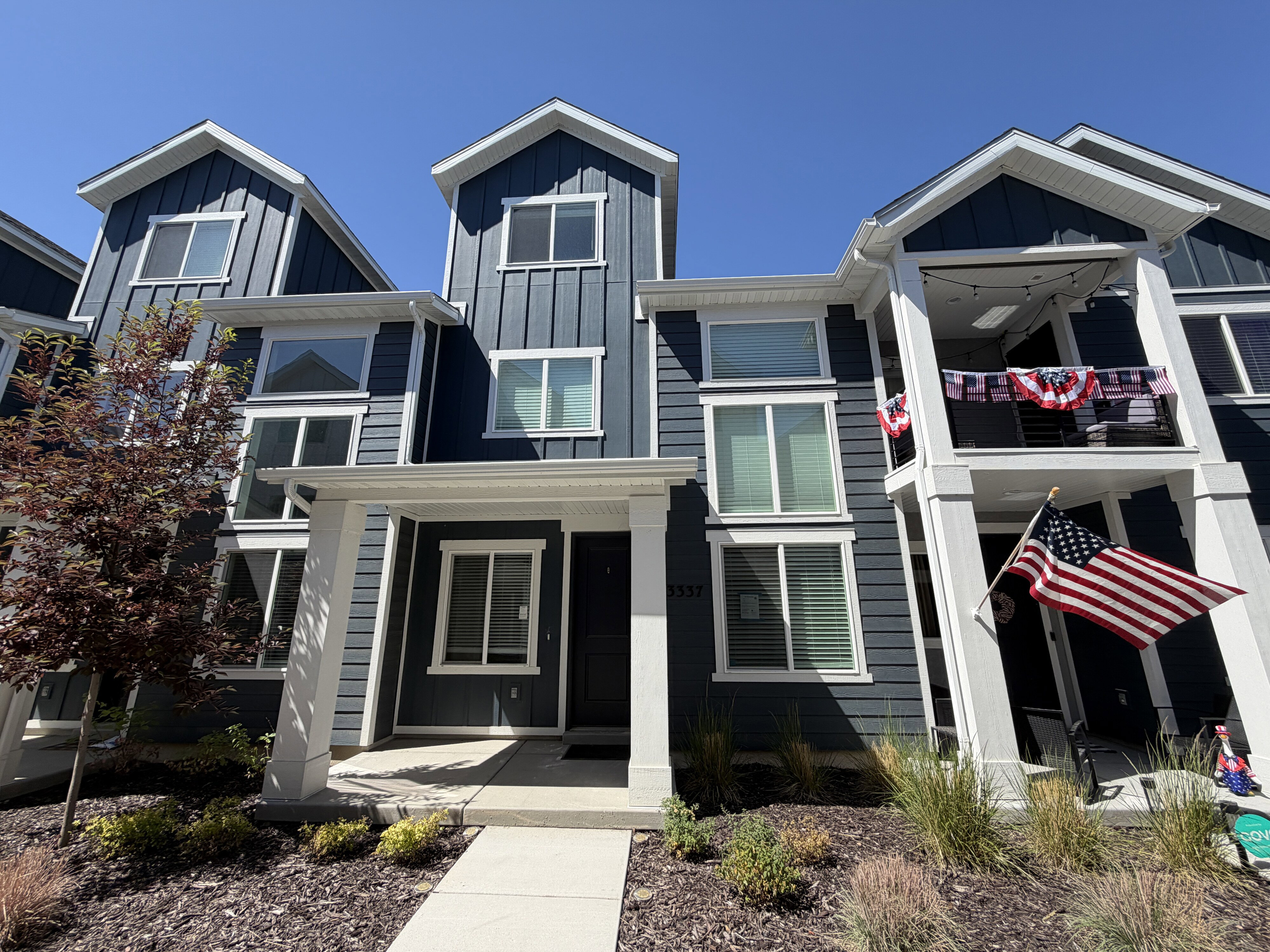 Contemporary multi-story exterior with dark blue siding and white trim